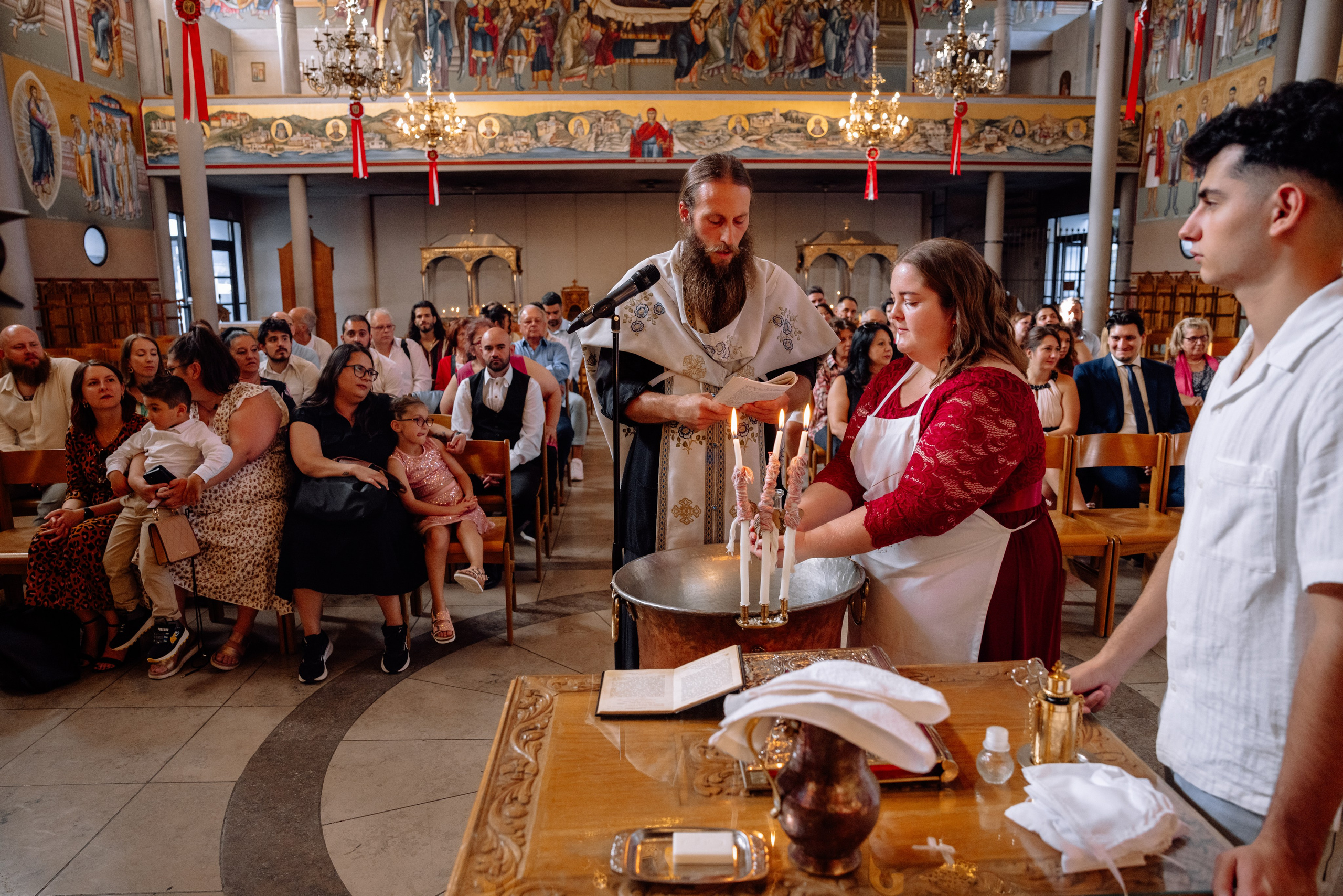 Gäste beobachten die Taufe in der Kirche Pasing