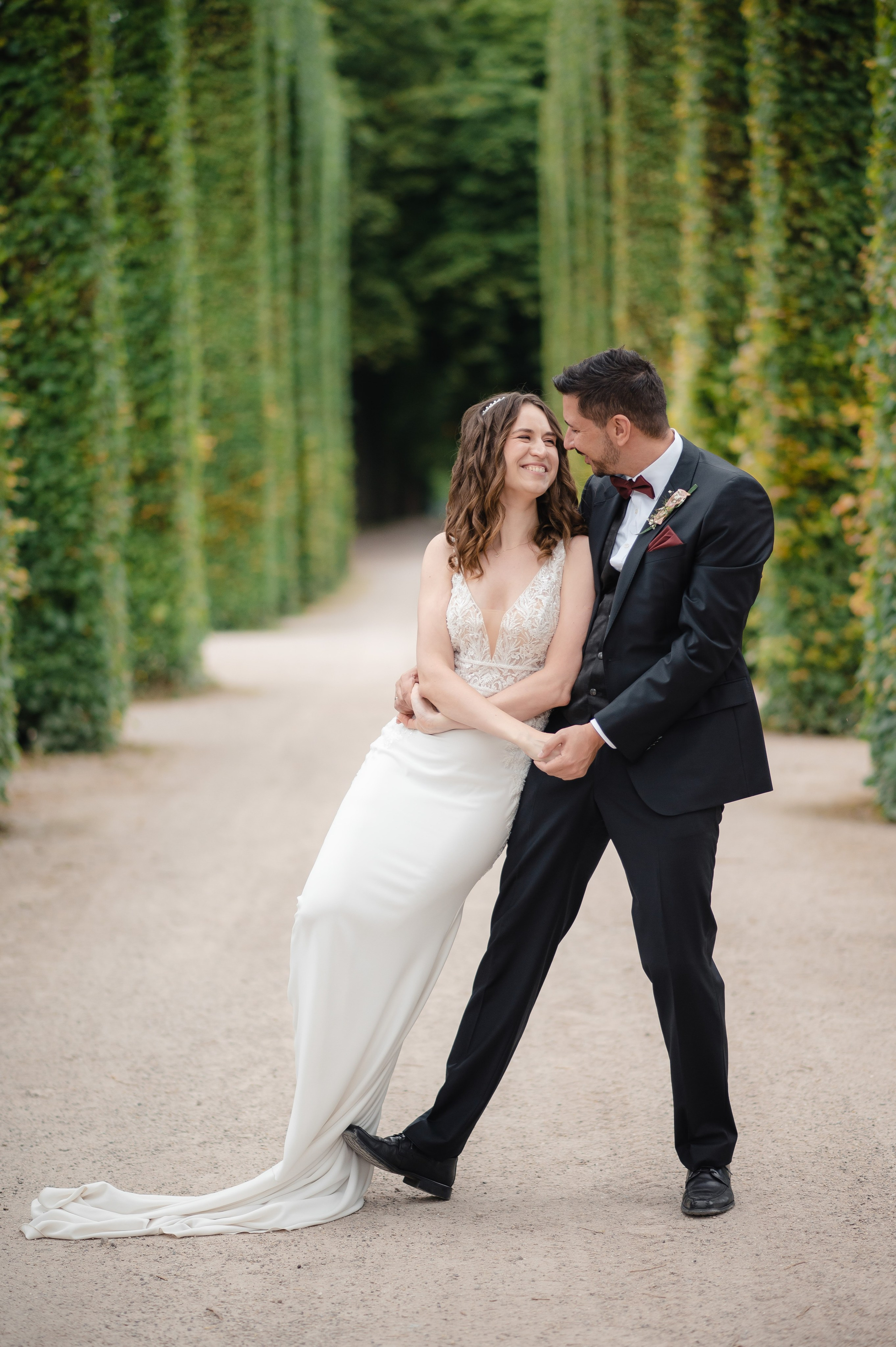 Brautpaar bei einem romantischen Hochzeitsshooting zwischen hohen Hecken im Schlossgarten