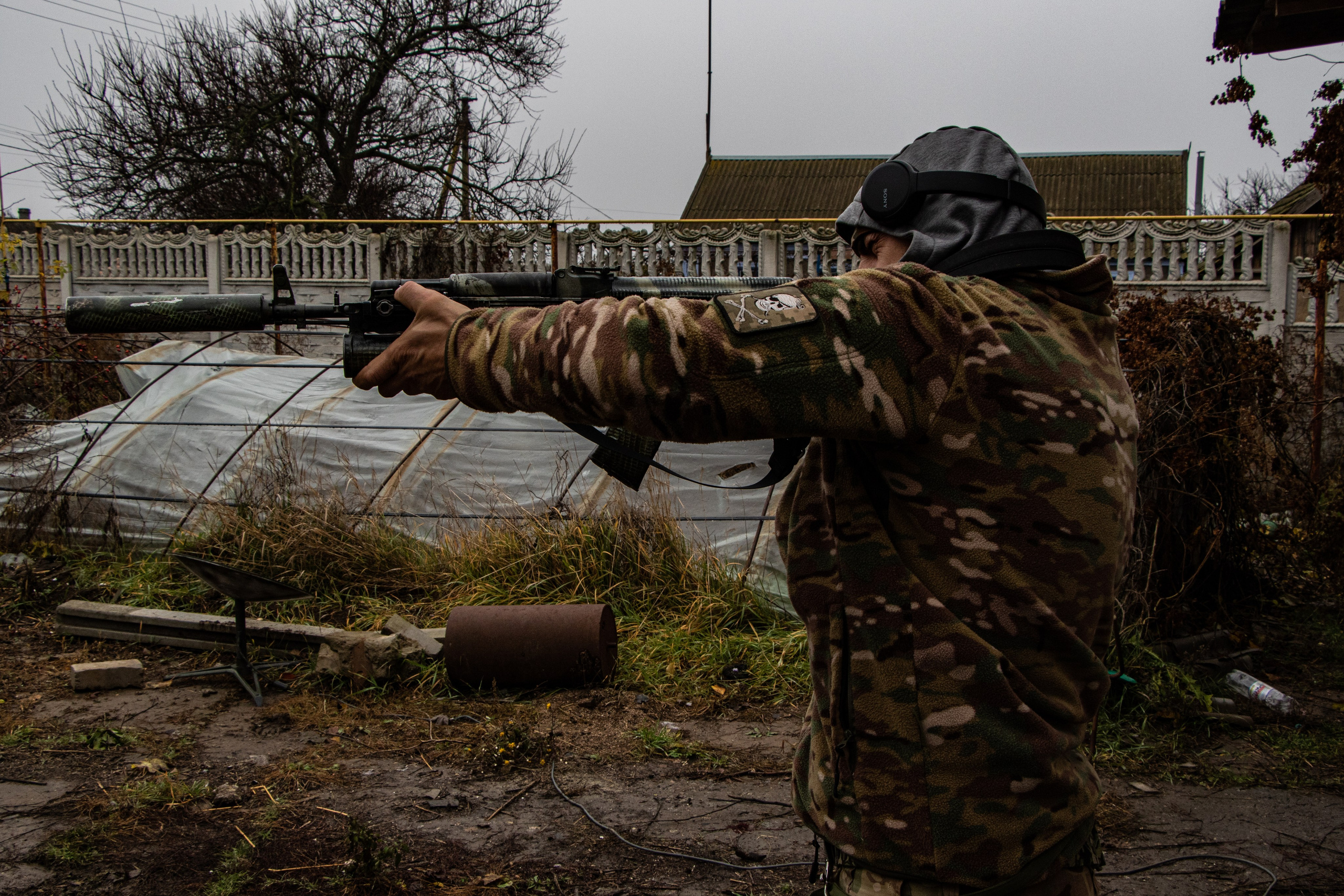Un militaire se prépare au combat près de Kherson, ajustant son équipement dans l’attente d’une nouvelle offensive dans la région.