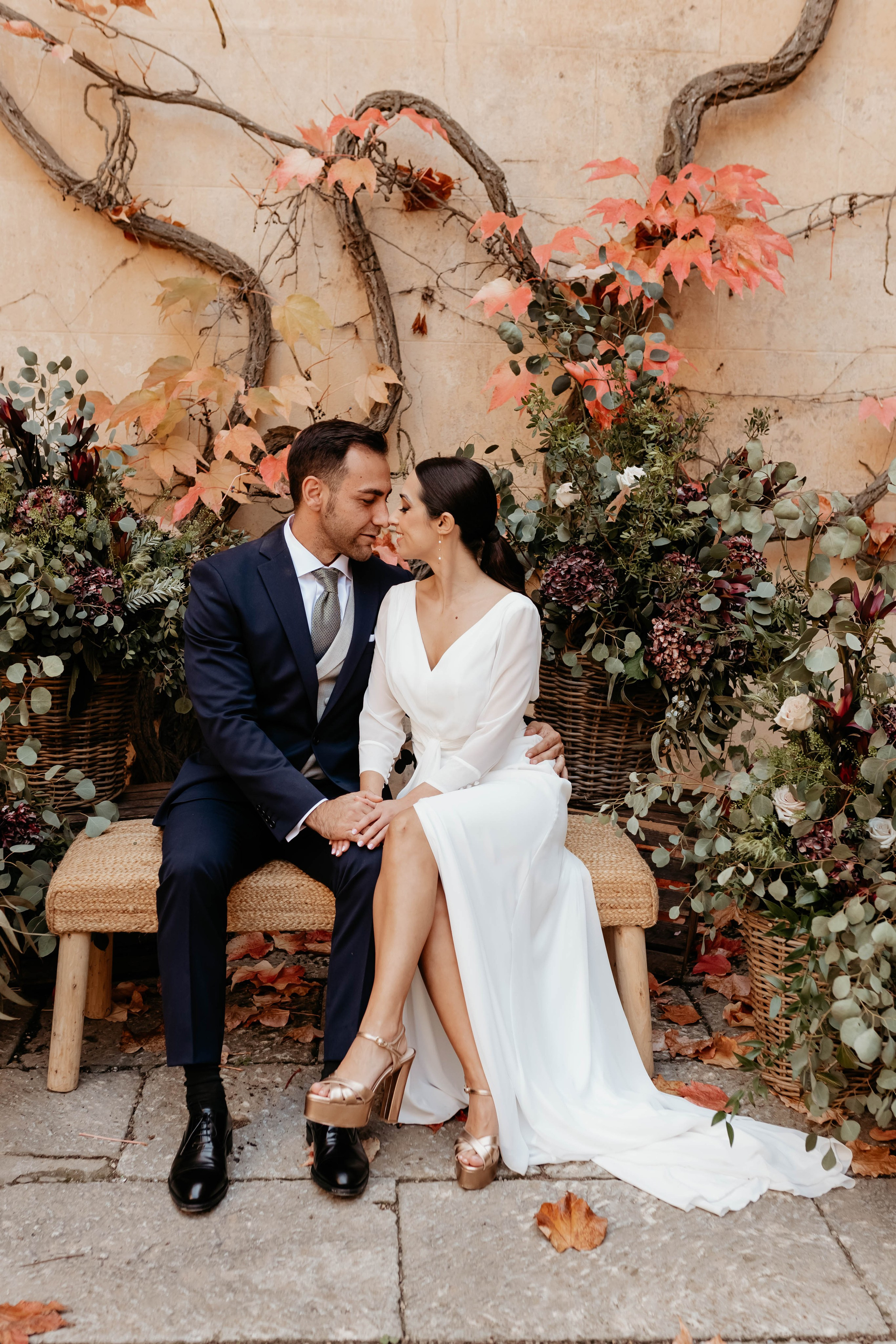 Novios sentados rodeados de decoración otoñal en Finca Torrefiel