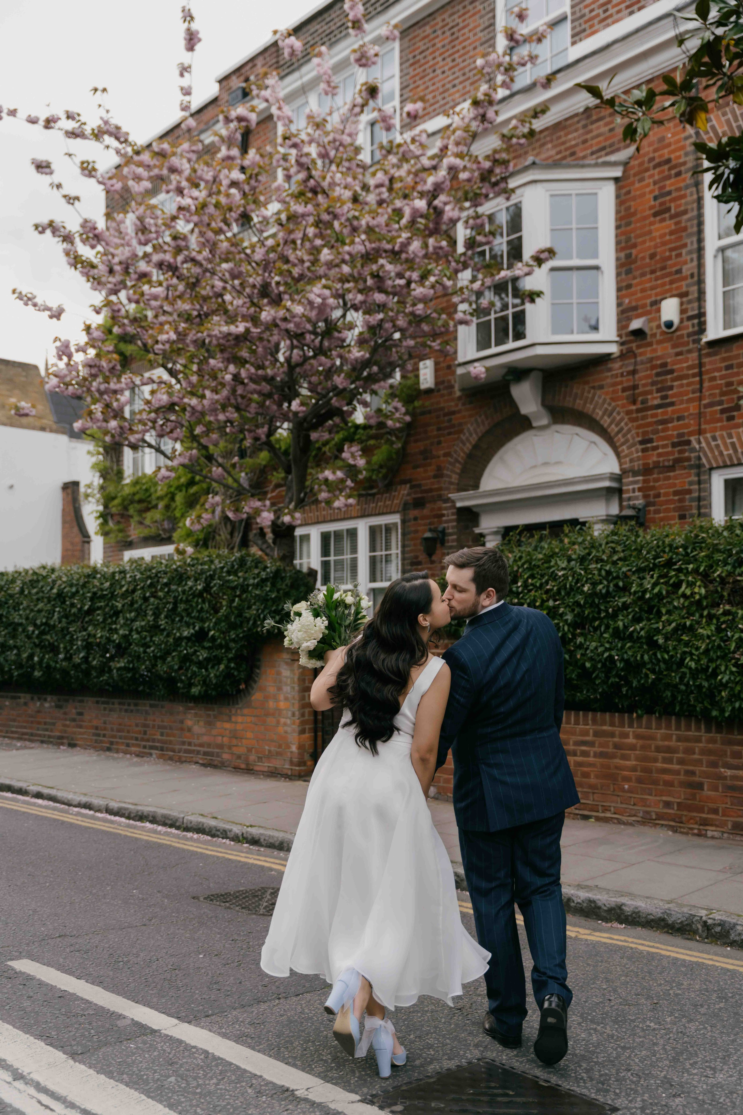 Chelsea London wedding photos with cherry blossom, bride and groom walking through blooming spring streets
