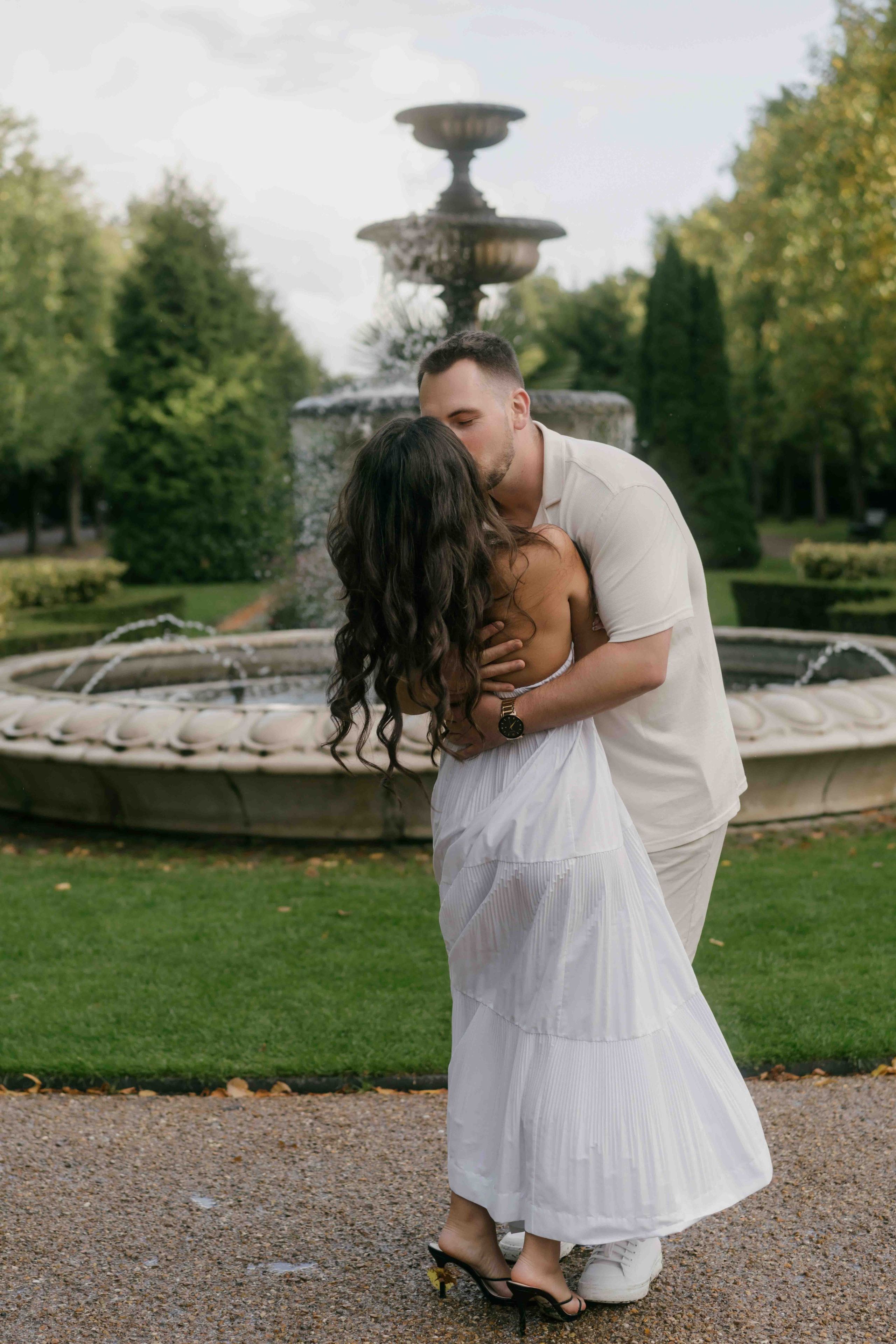 Couple hugging after proposal in Regent’s Park London, romantic candid moment