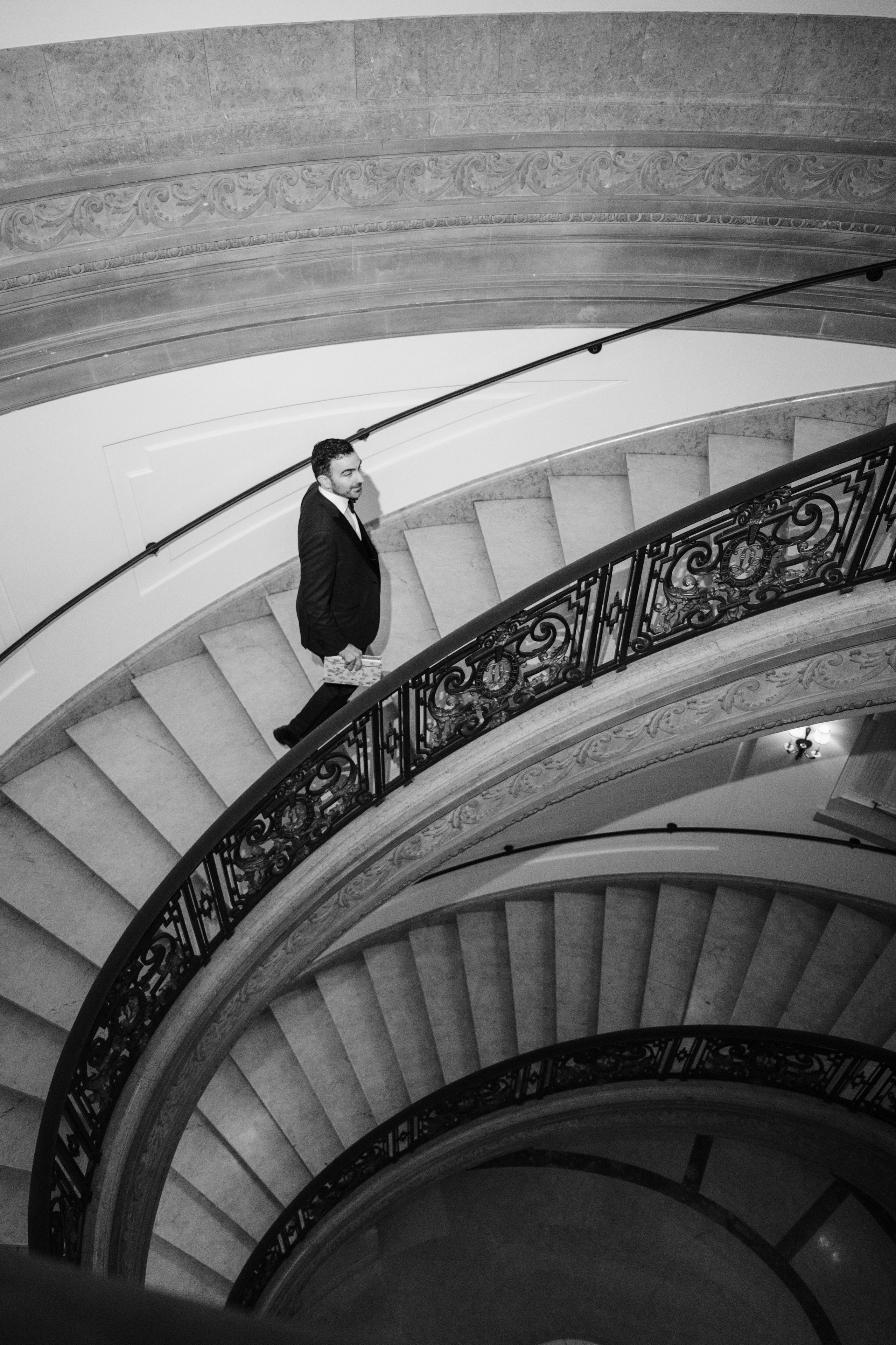 a man in a suit standing on the stairs