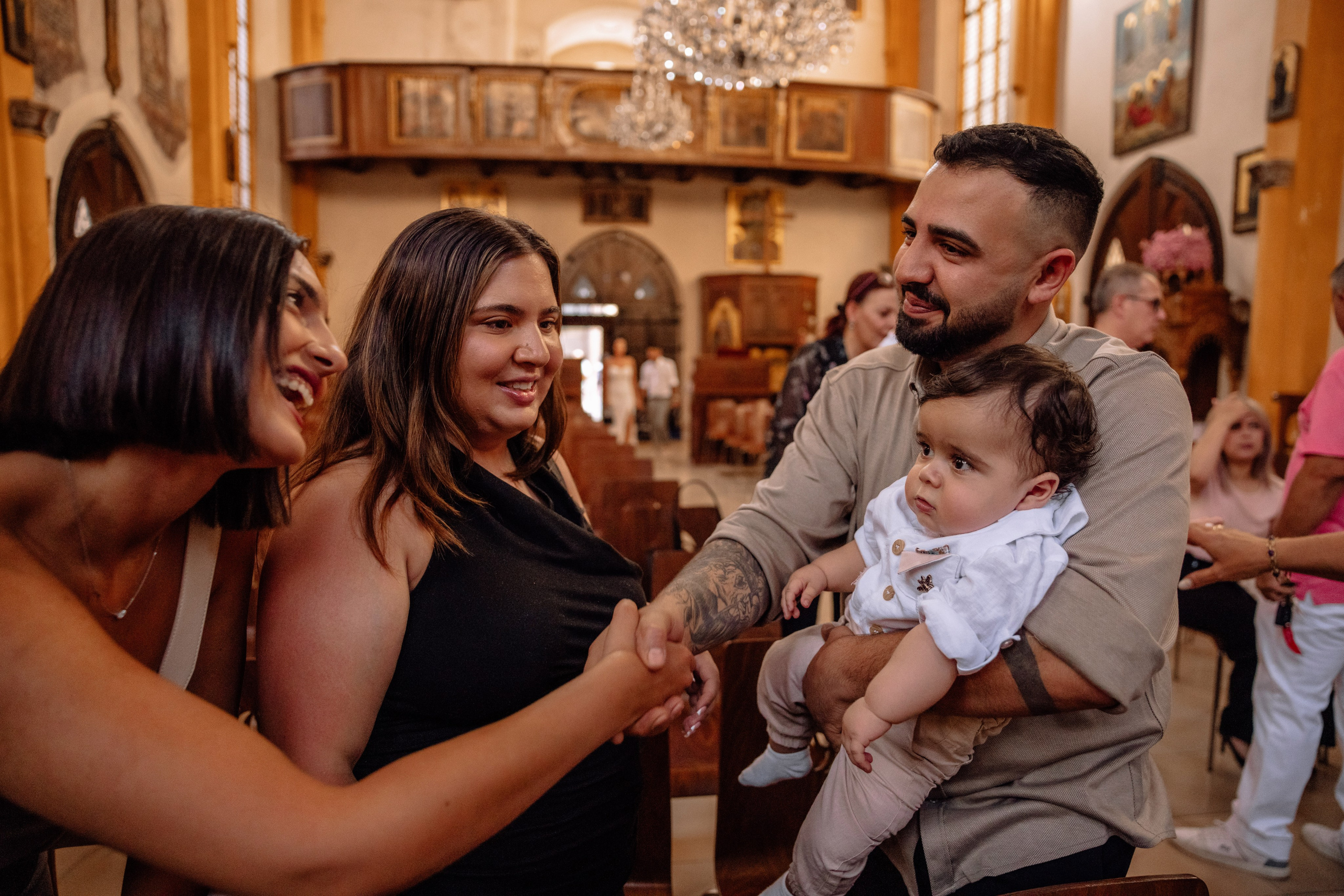 Eltern und Gäste segnen Baby nach der Taufe