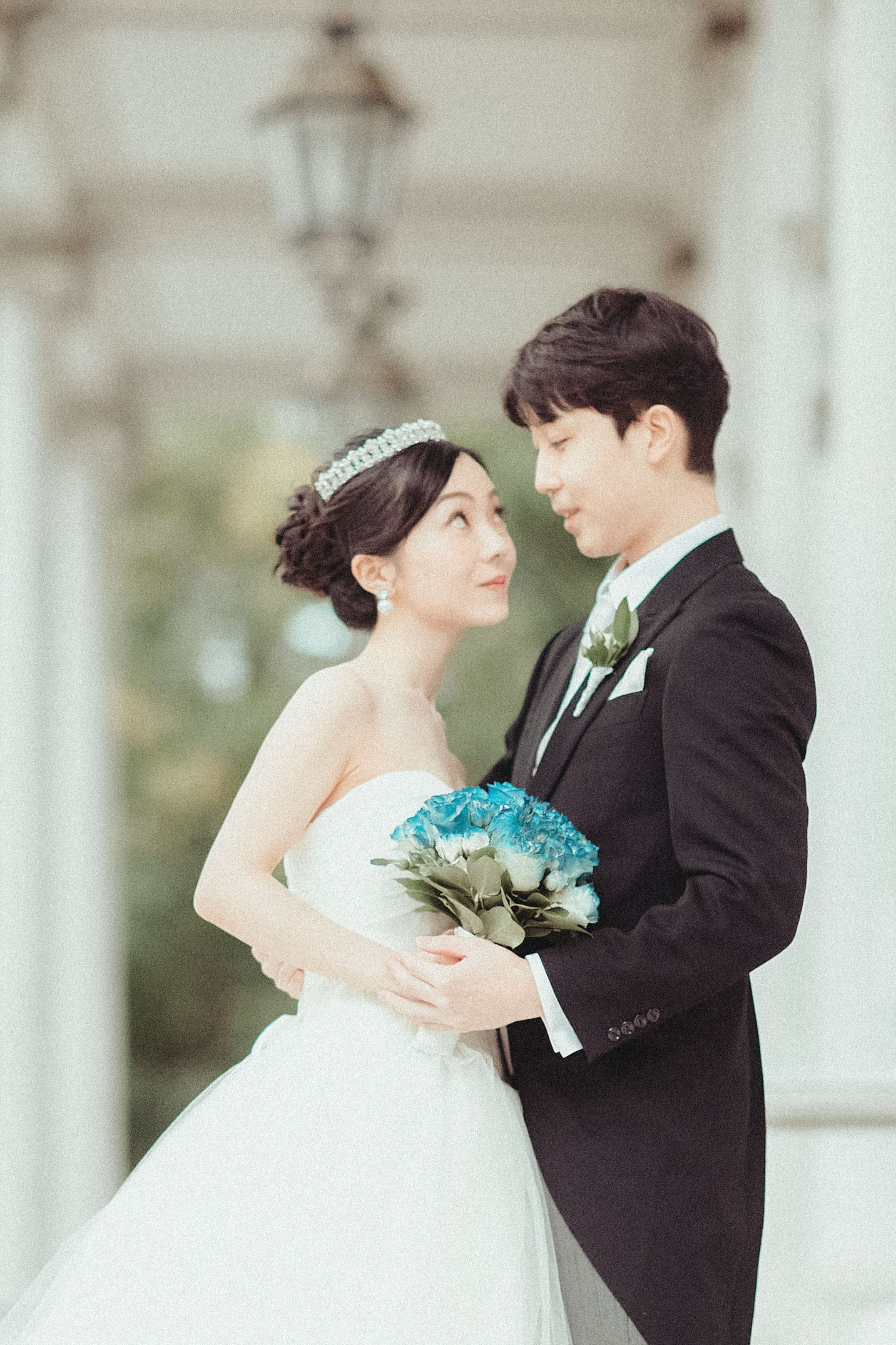 The bride looks towards her groom on the terrace of the Palais Coburg.