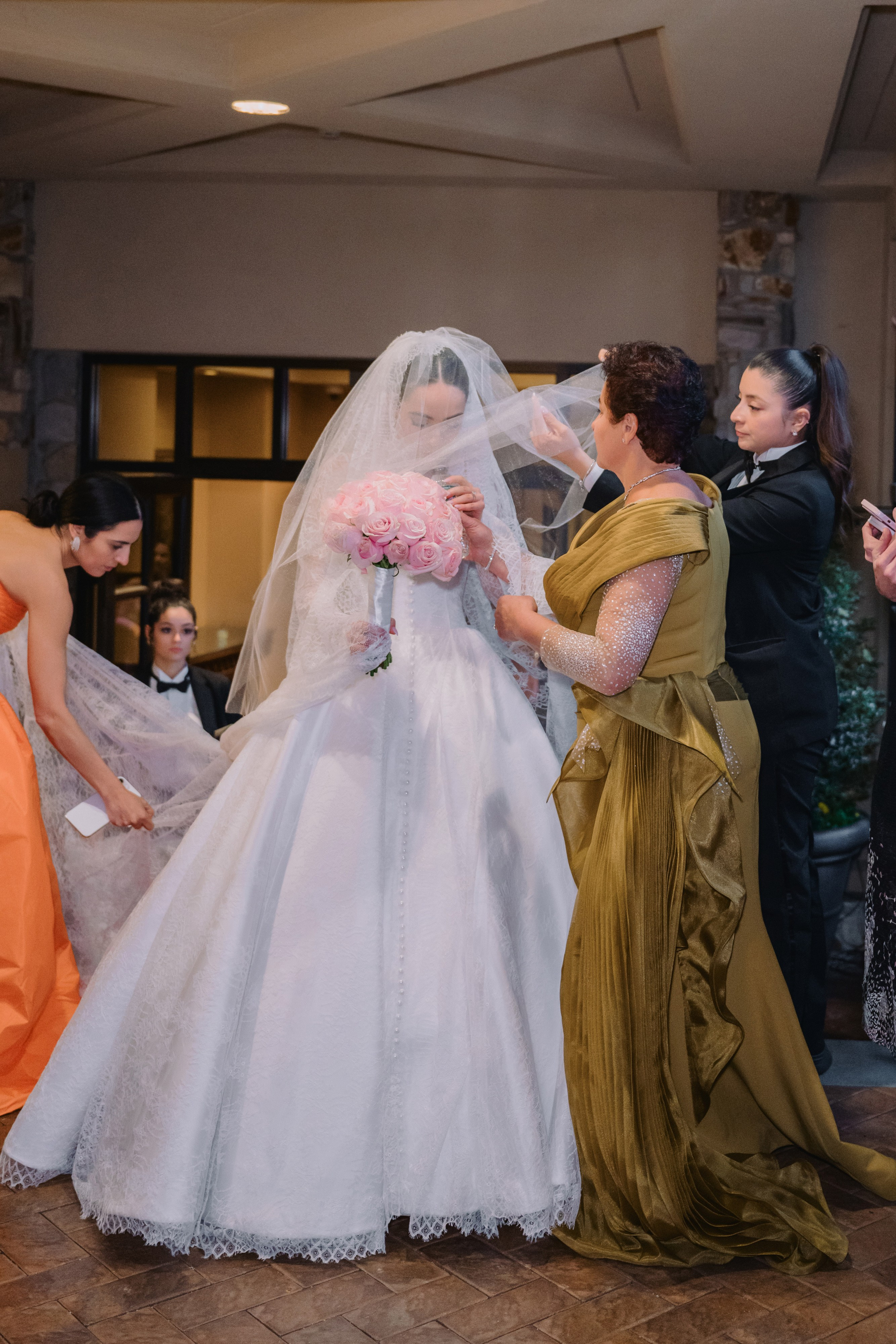 a bride is putting her veil on a bridesmart