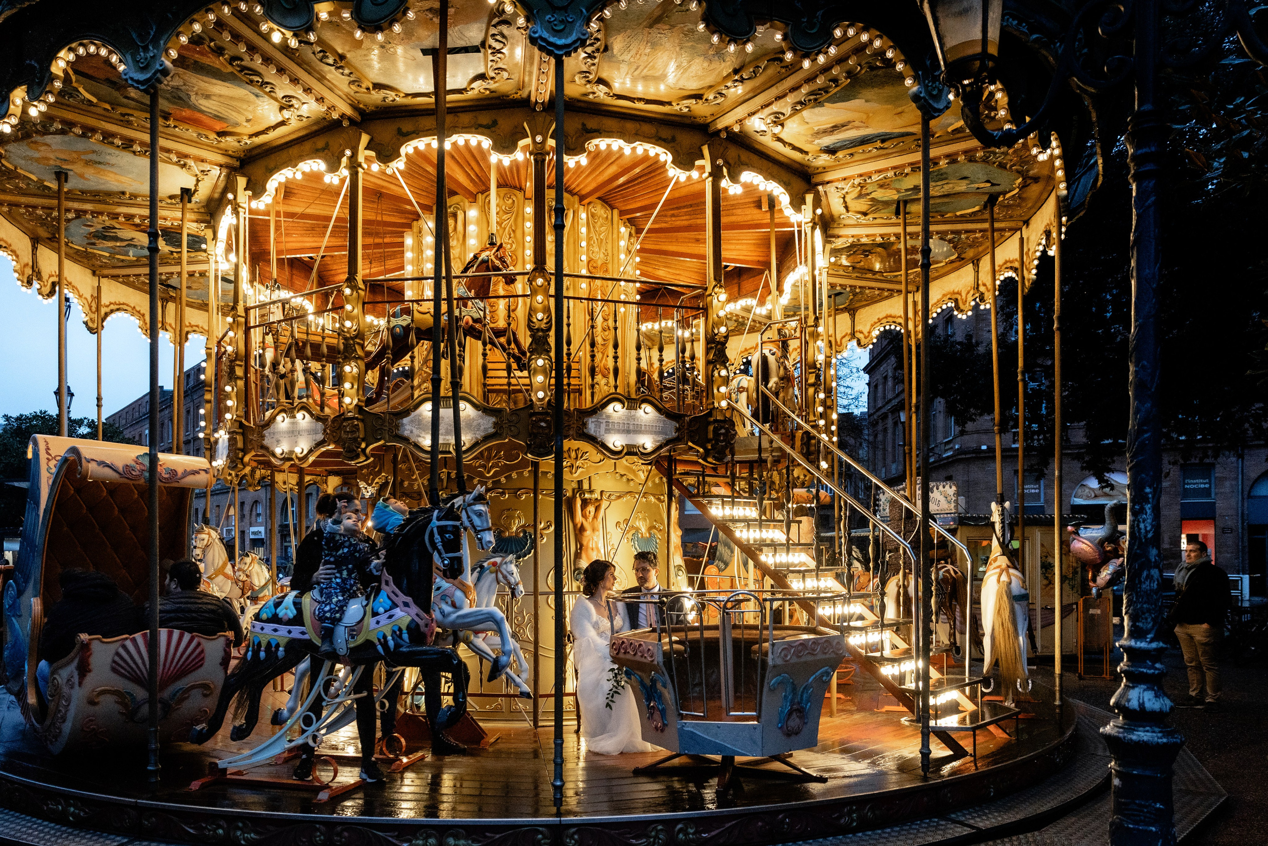 Couple of newlyweds on the carousel of Place Wilson Toulouse