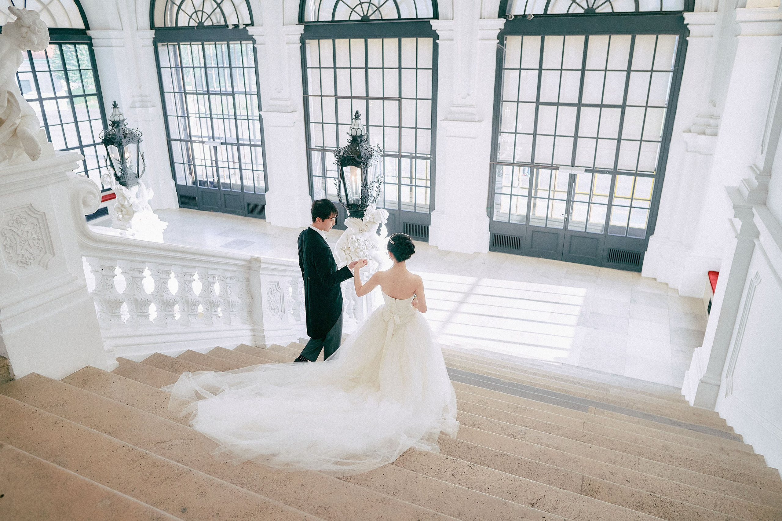 The bride and groom walk down the historic Grand Staircase.