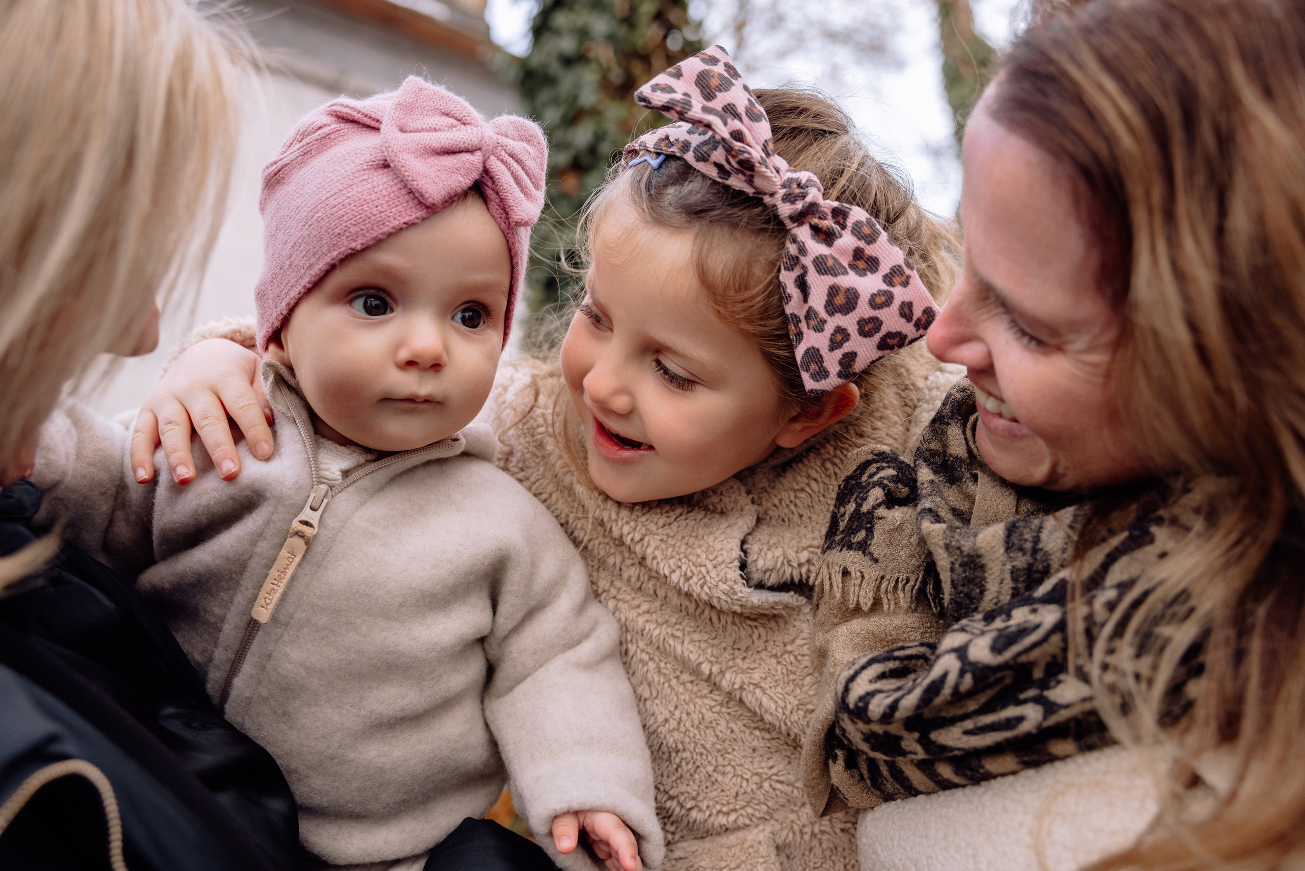 Eltern und Geschwister umarmen Baby – emotionale Taufszene