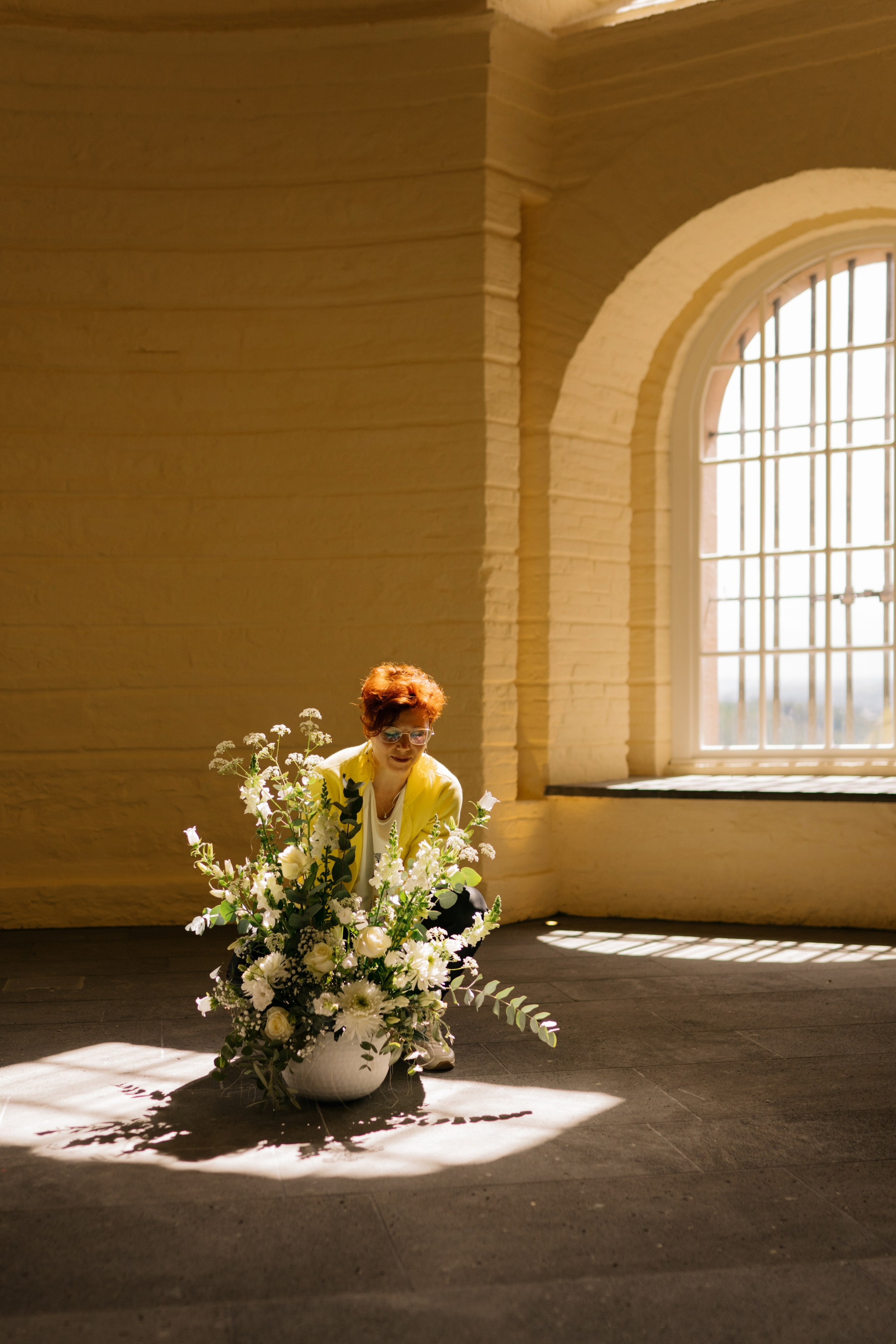 Floristin und Einrichtungsberaterin, die eine stilvolle Blumenarrangements für ein Event vorbereitet
