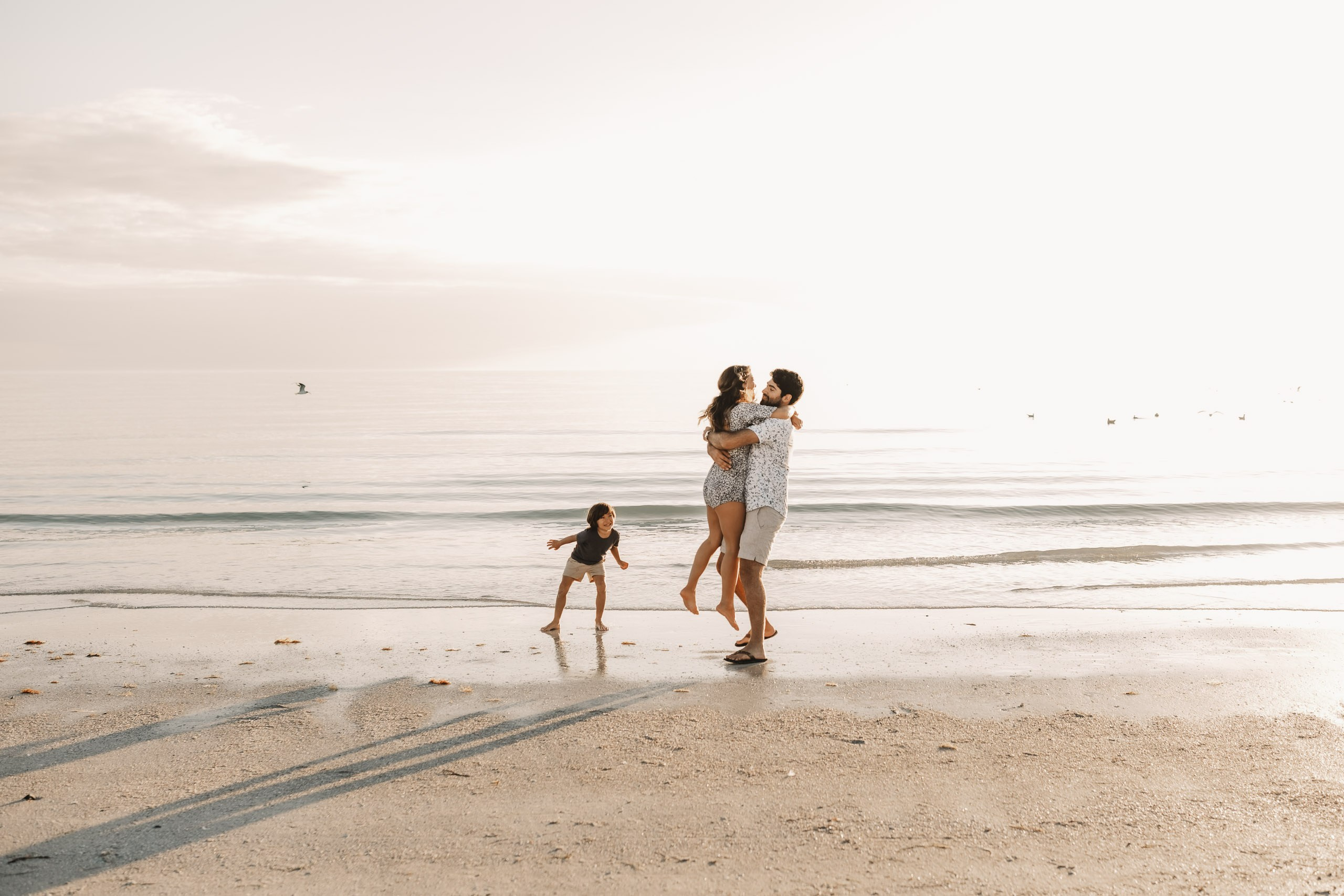 Wide shot of a family on the shore of Siesta Key Beach under a clear Florida sky