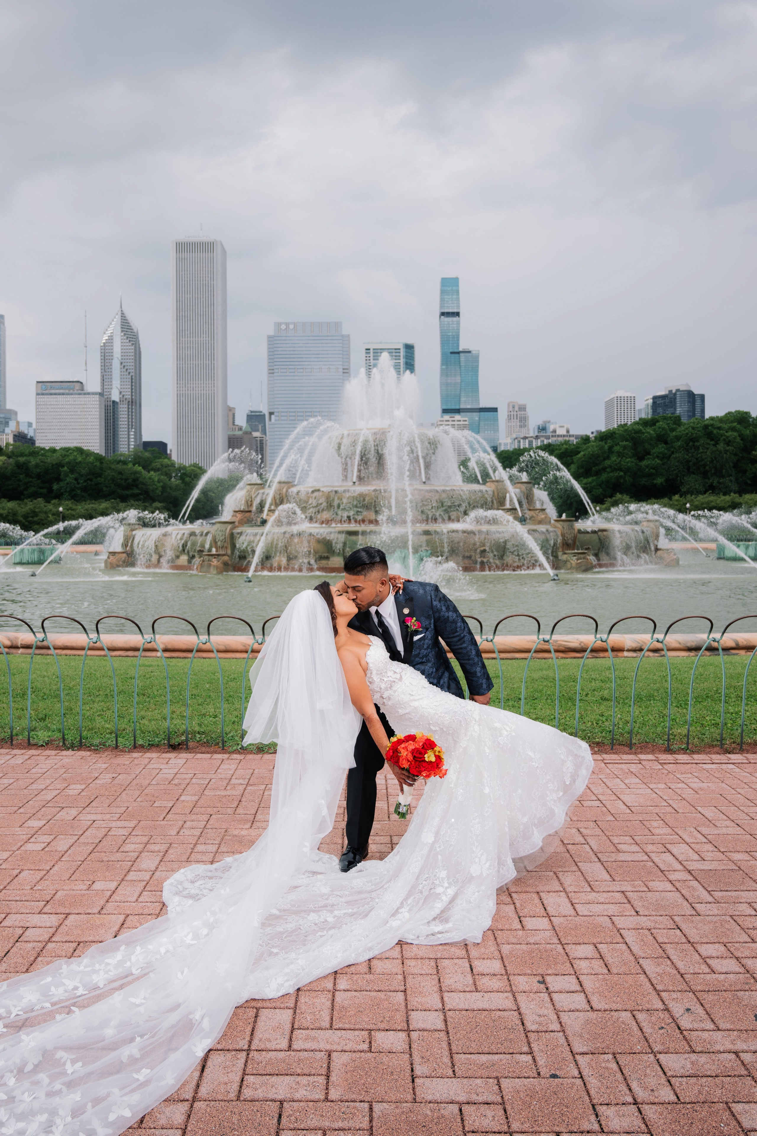 a bride and groom kissing in front of the buckingham gardens