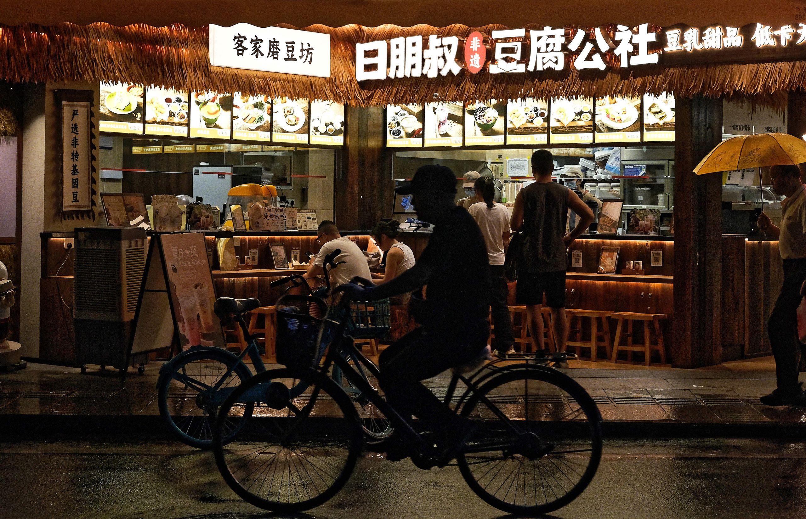 A rainy evening in Guangzhou. One cyclist, one warm storefront, countless untold stories.