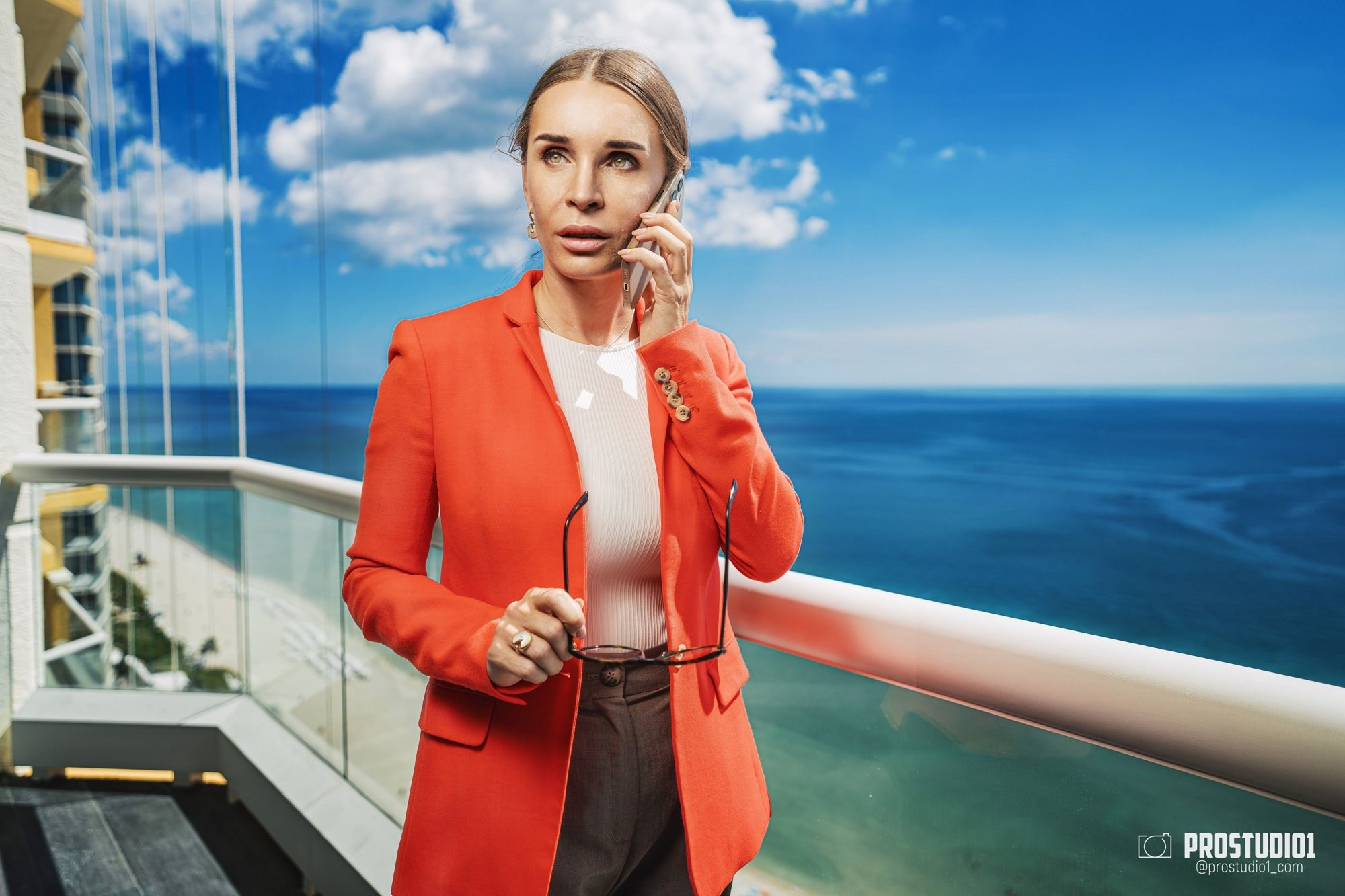 Хедшот для LinkedIn Майами — деловая женщина в красном блейзере с телефоном, балкон у океана