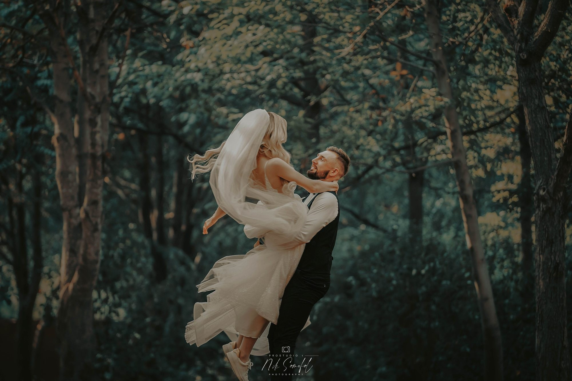 Romantic wedding photography South Florida — groom lifting the bride in a forest