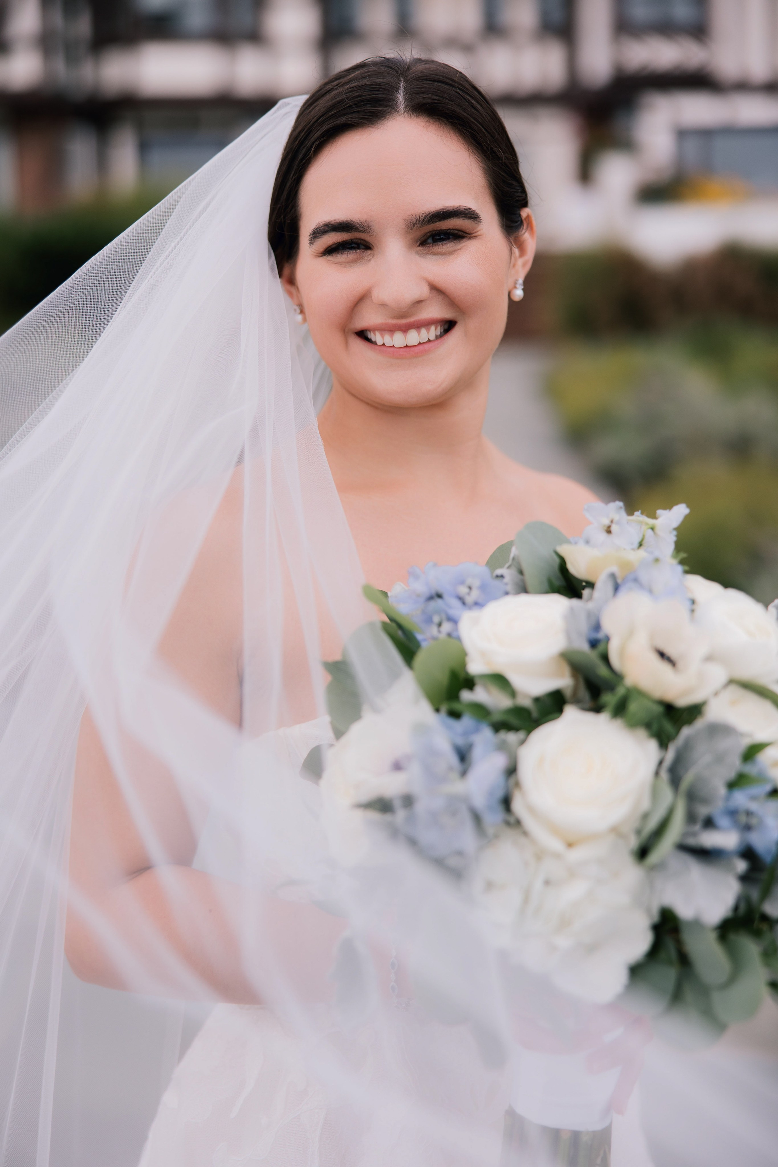 a bride smiles while holding her bouquet