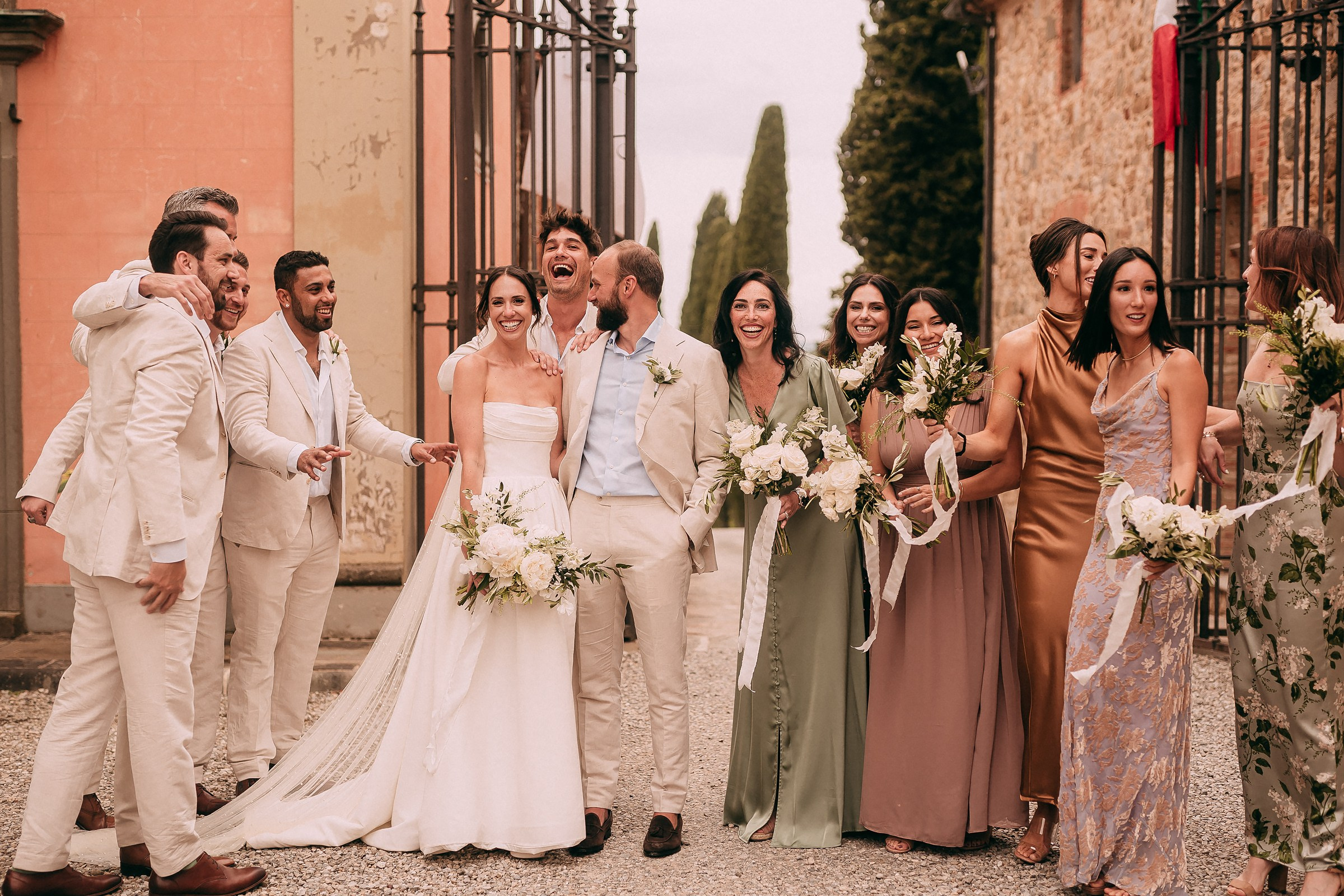Joyful moments with the bridal party and groomsmen sharing laughter and smiles during a picturesque wedding in Tuscany
