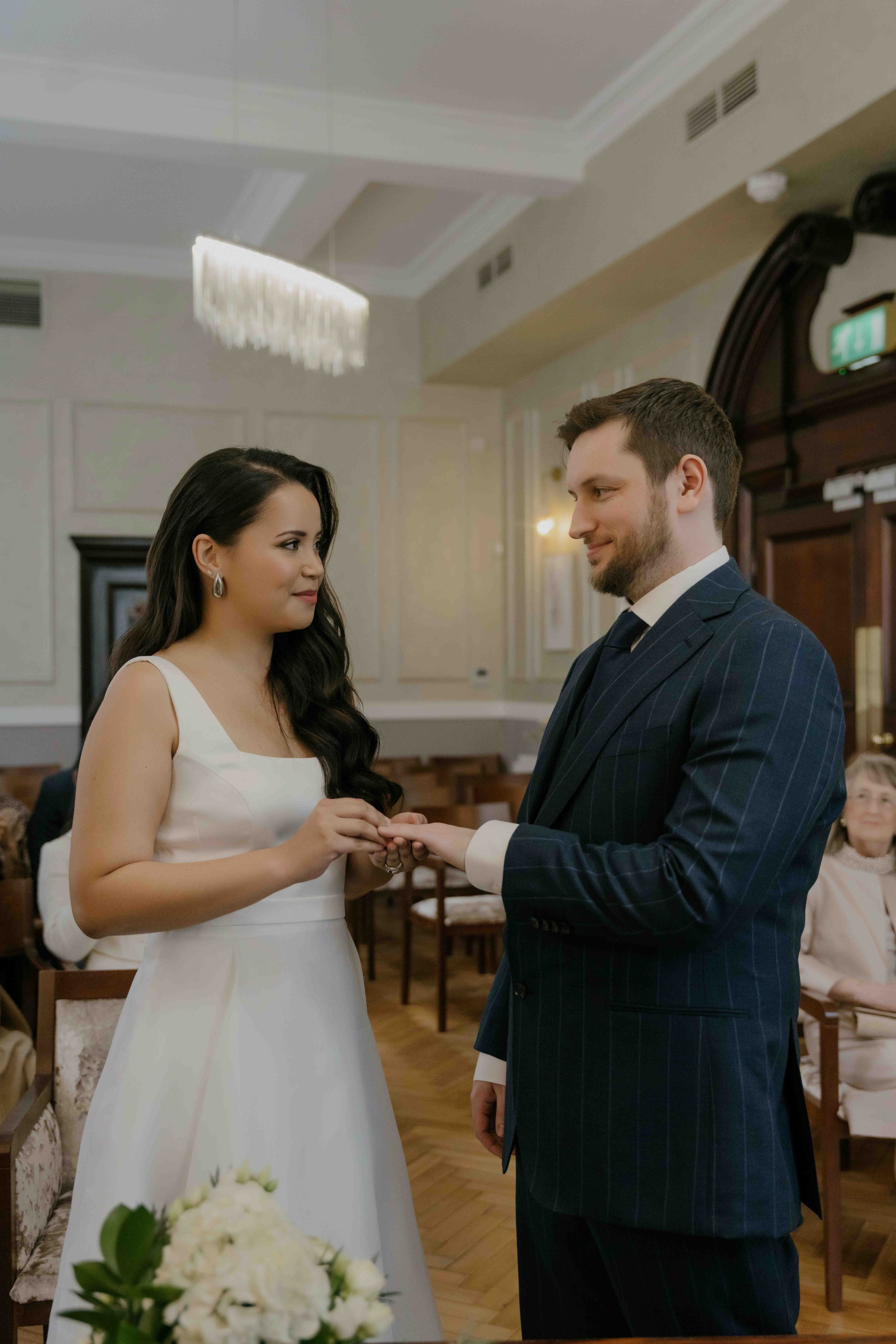 Chelsea Town Hall wedding ceremony in London, intimate civil wedding, bride and groom exchanging vows, elegant documentary photography