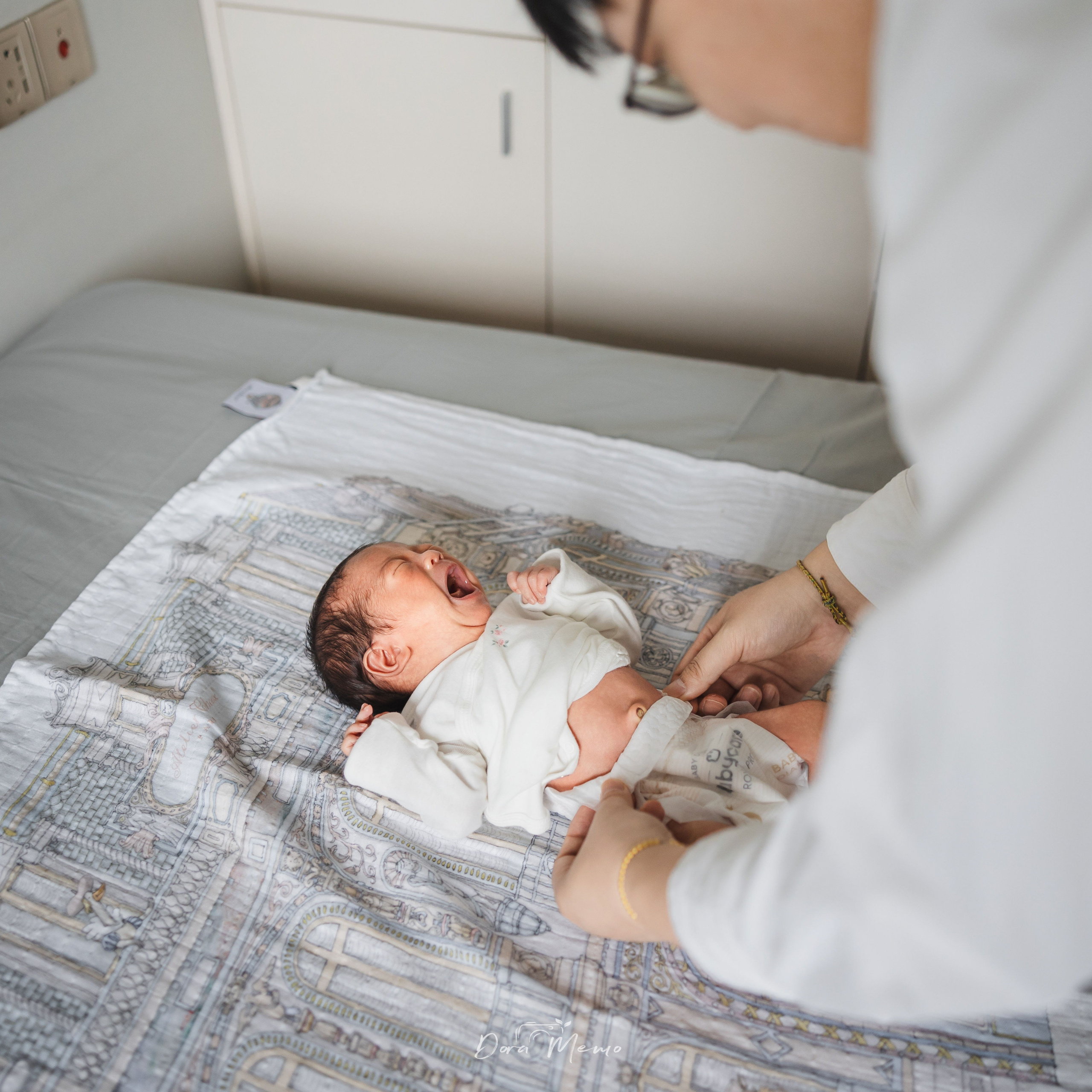 Father changing the newborn's diaper on the bed, raw and real family life photography