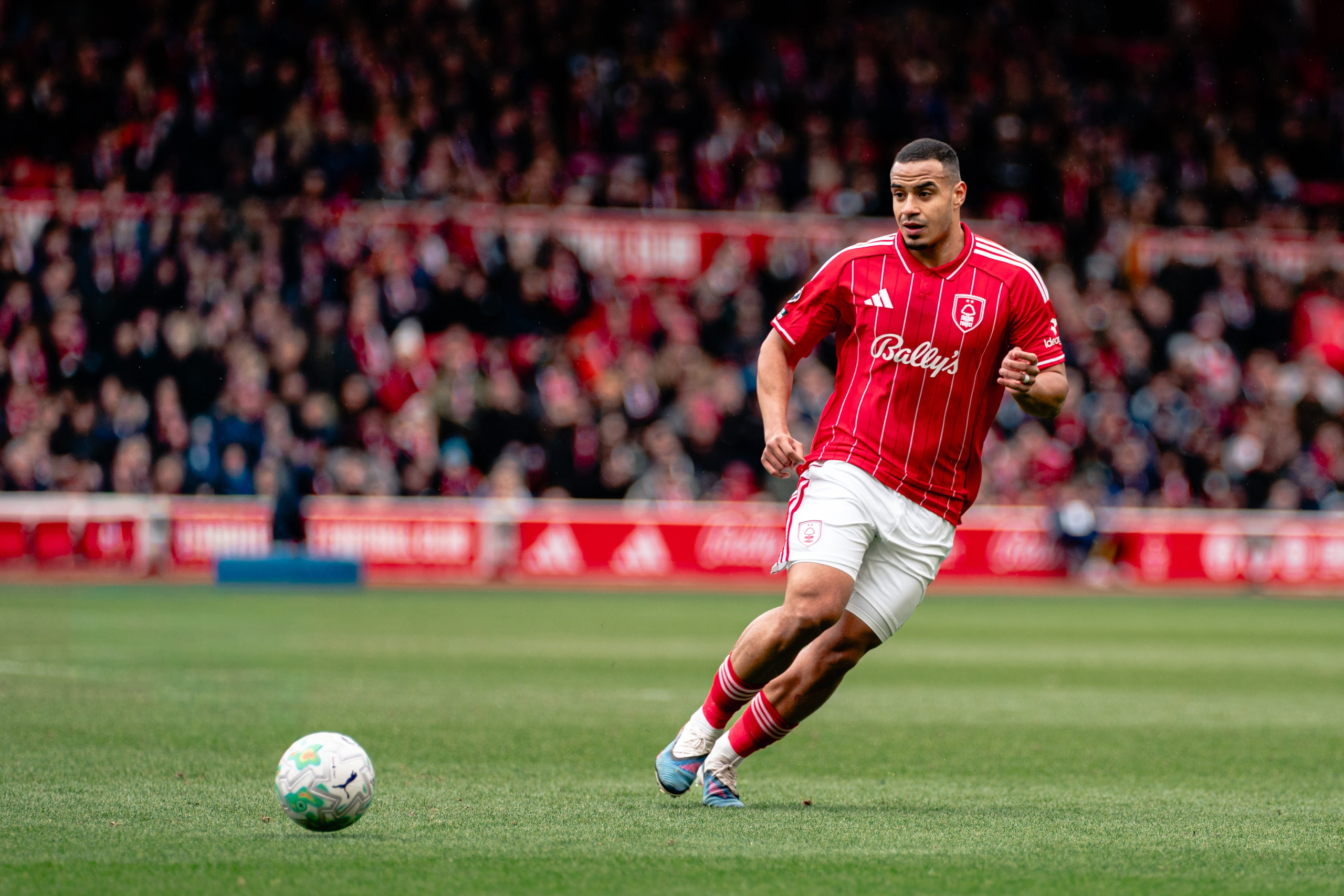 Nottingham Forest player striking the ball during the Premier League fixture against Fulham at the City Ground
