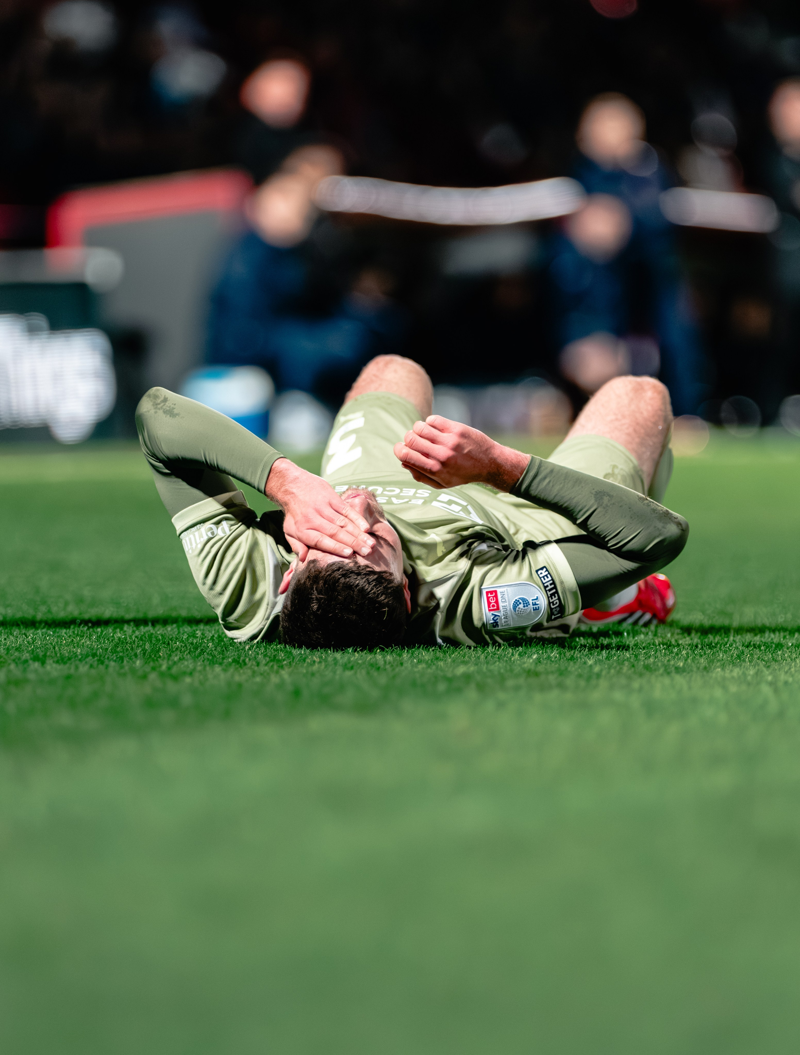 Leyton Orient player lying on the pitch after a challenge during the League One fixture against Stevenage.