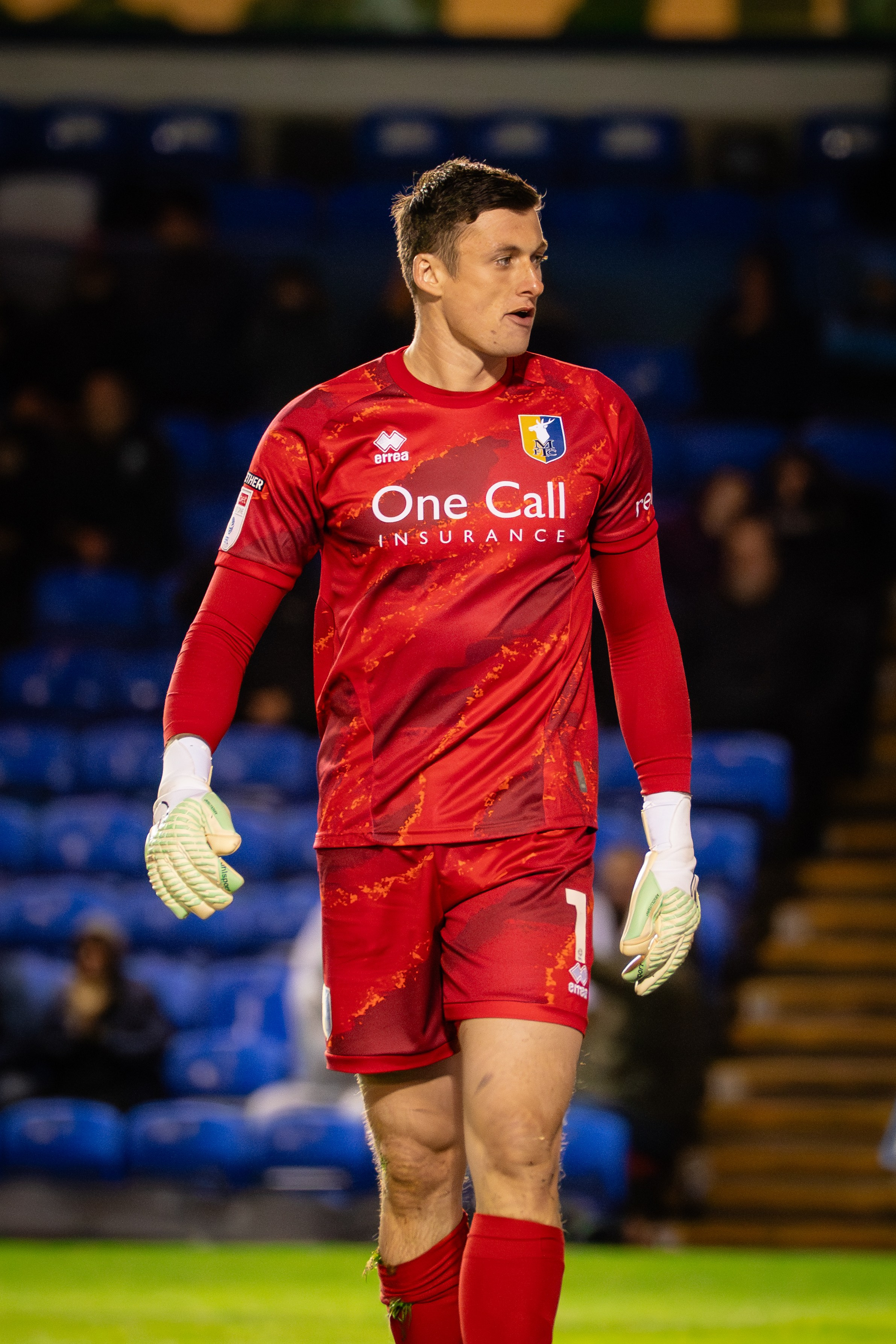 Mansfield Town goalkeeper in a red kit during the League One fixture against Peterborough United