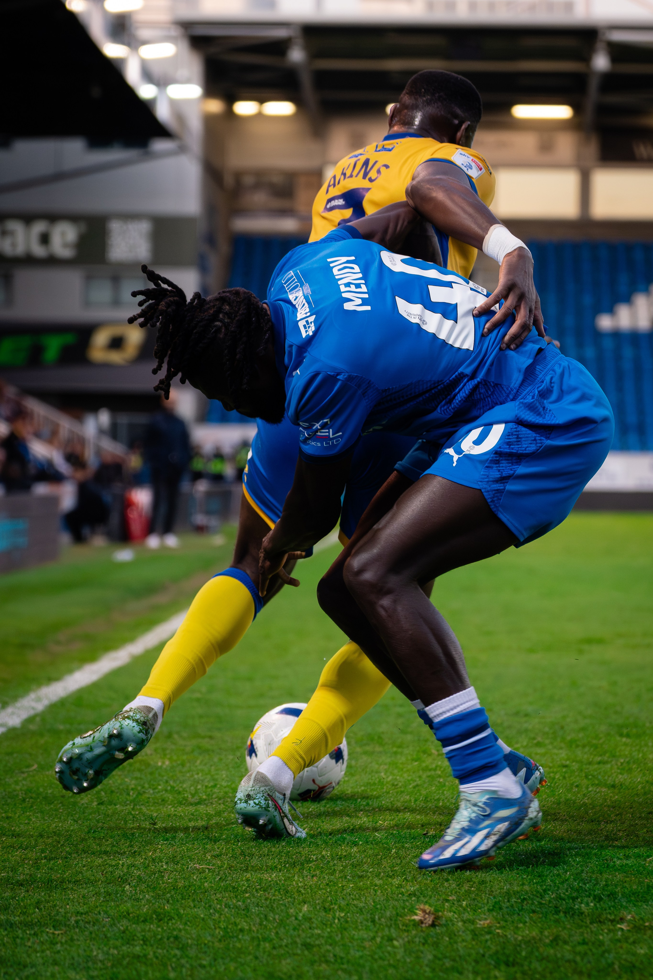 Peterborough United player shielding the ball from a Mansfield Town opponent during the League One match at the Weston Homes Stadium