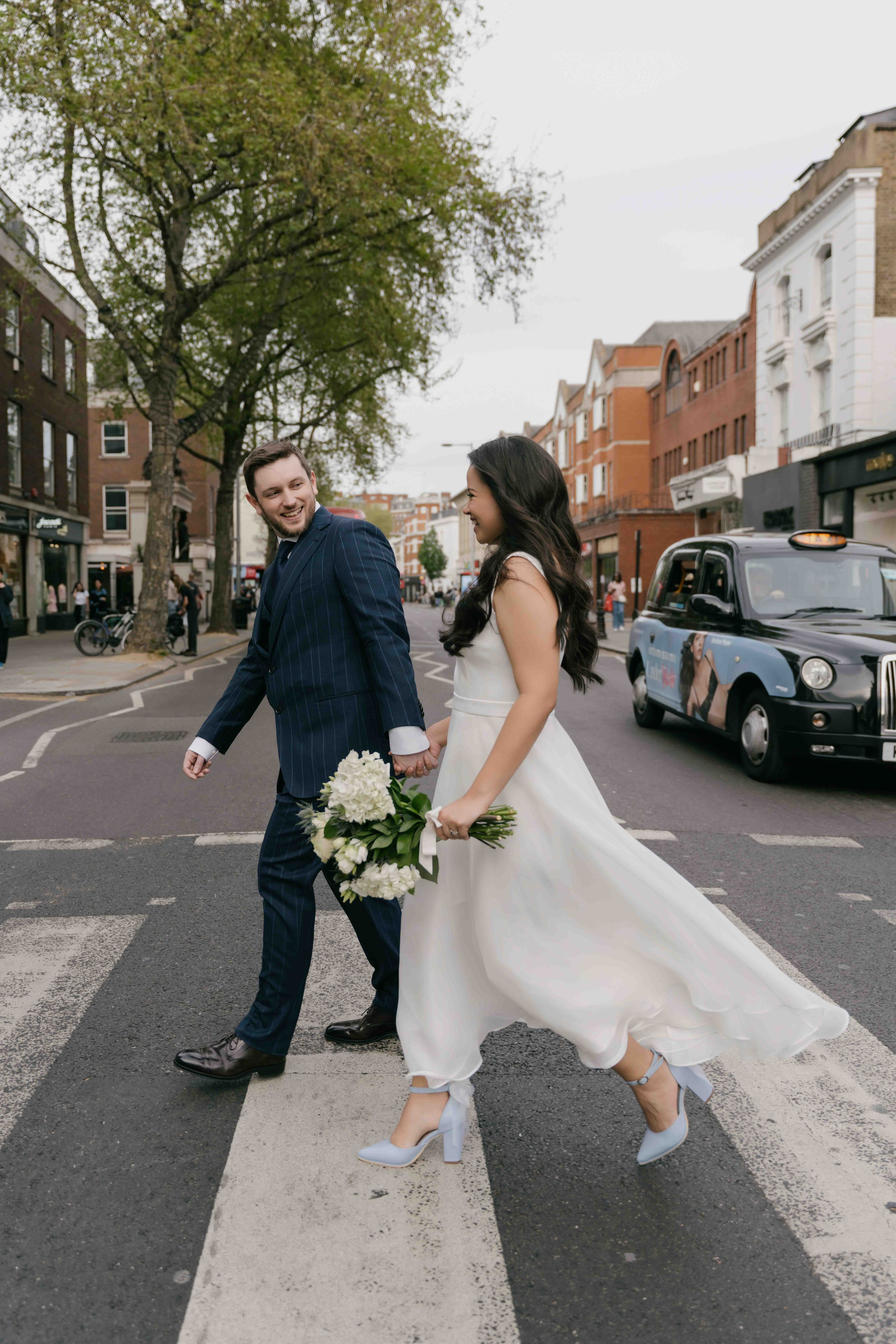 Bride and groom crossing street in Chelsea London, stylish editorial wedding photography
