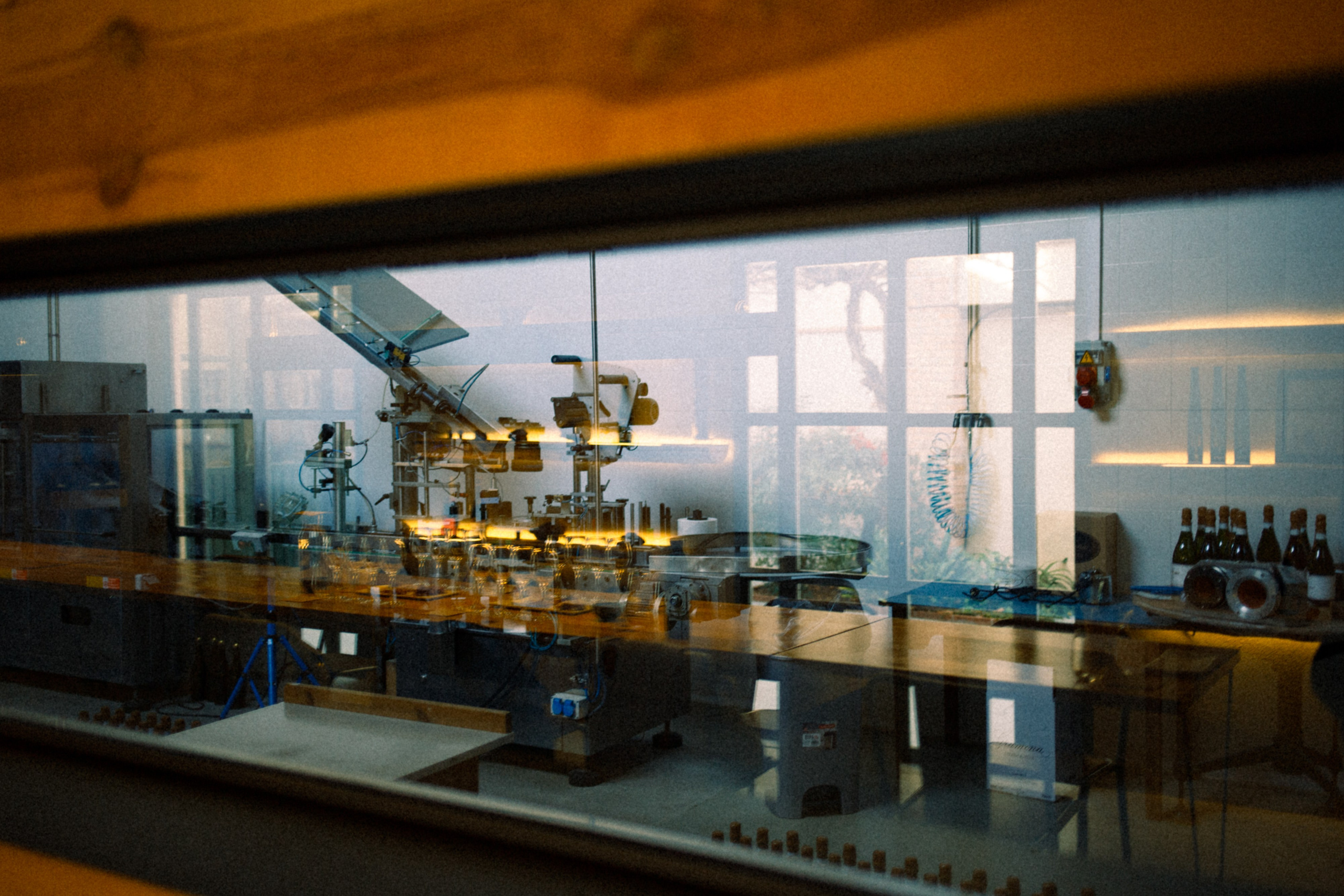 Aesthetic shot of wine bottling mechanism at the winery, with reflections and airy light