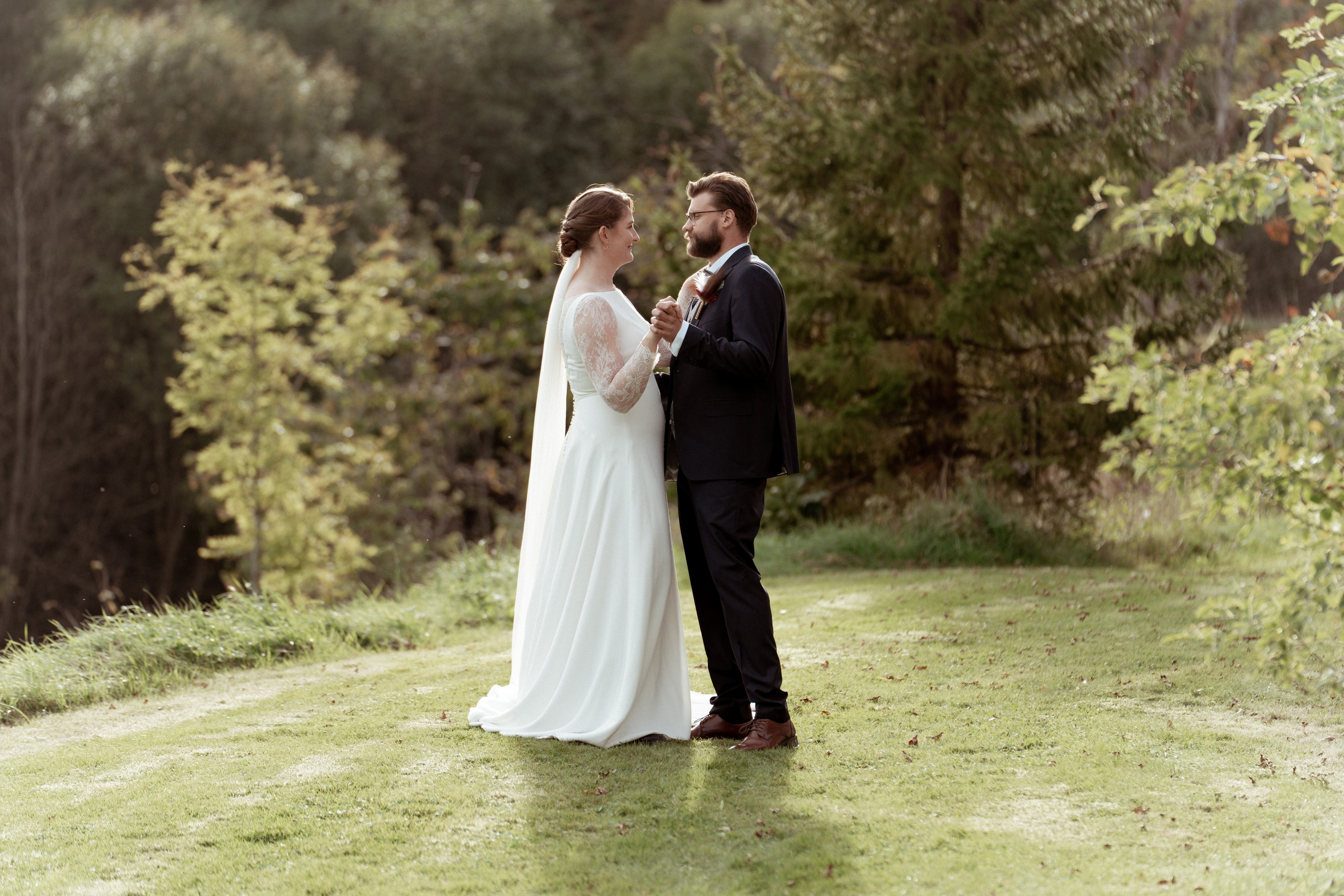 Det vakre brudeparet står ved siden av hverandre og ser på hverandre en sensommerdag
