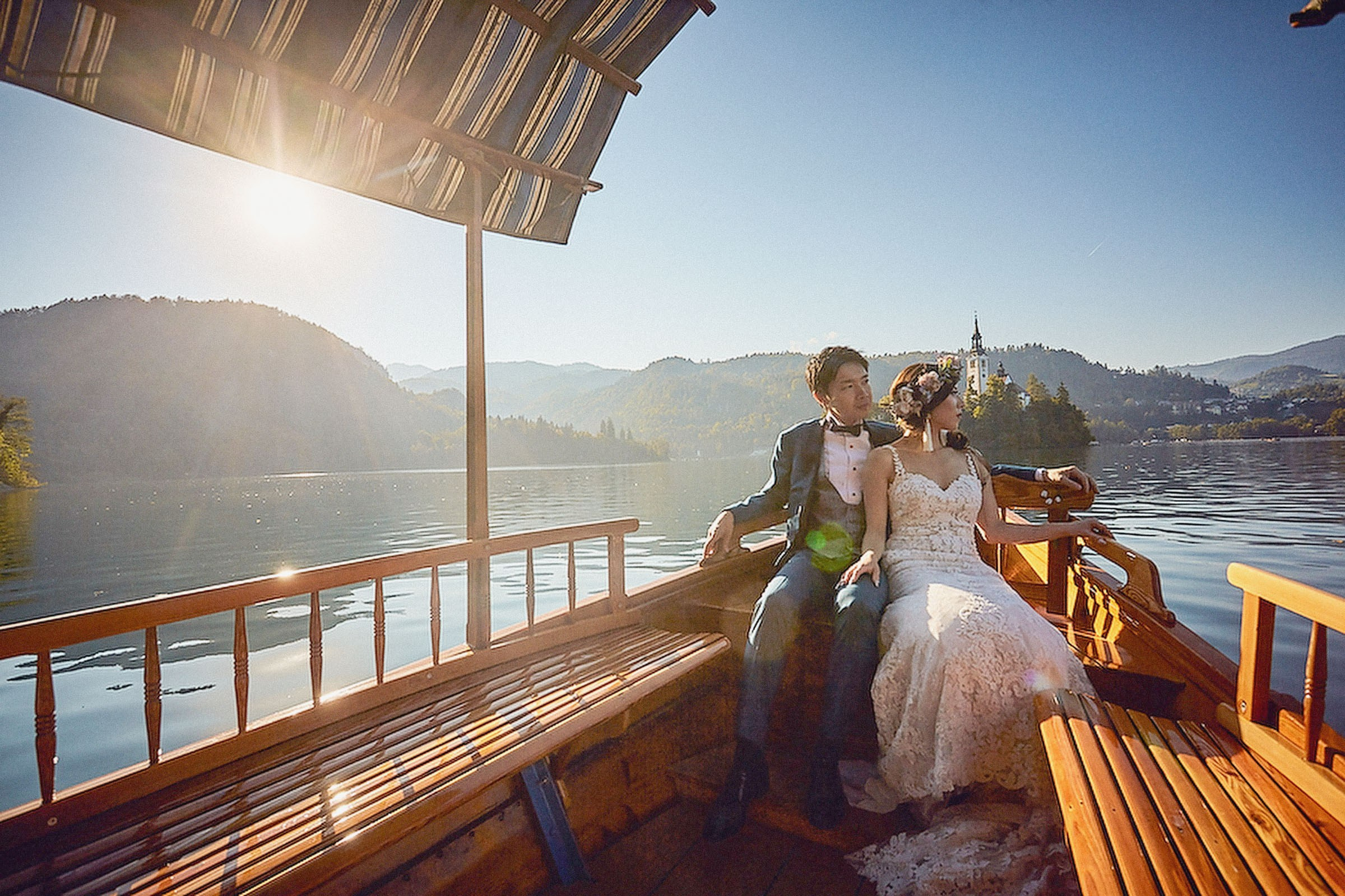 Beautiful young Japanese couple in traditional attire savor moments together on a boat near sunset.