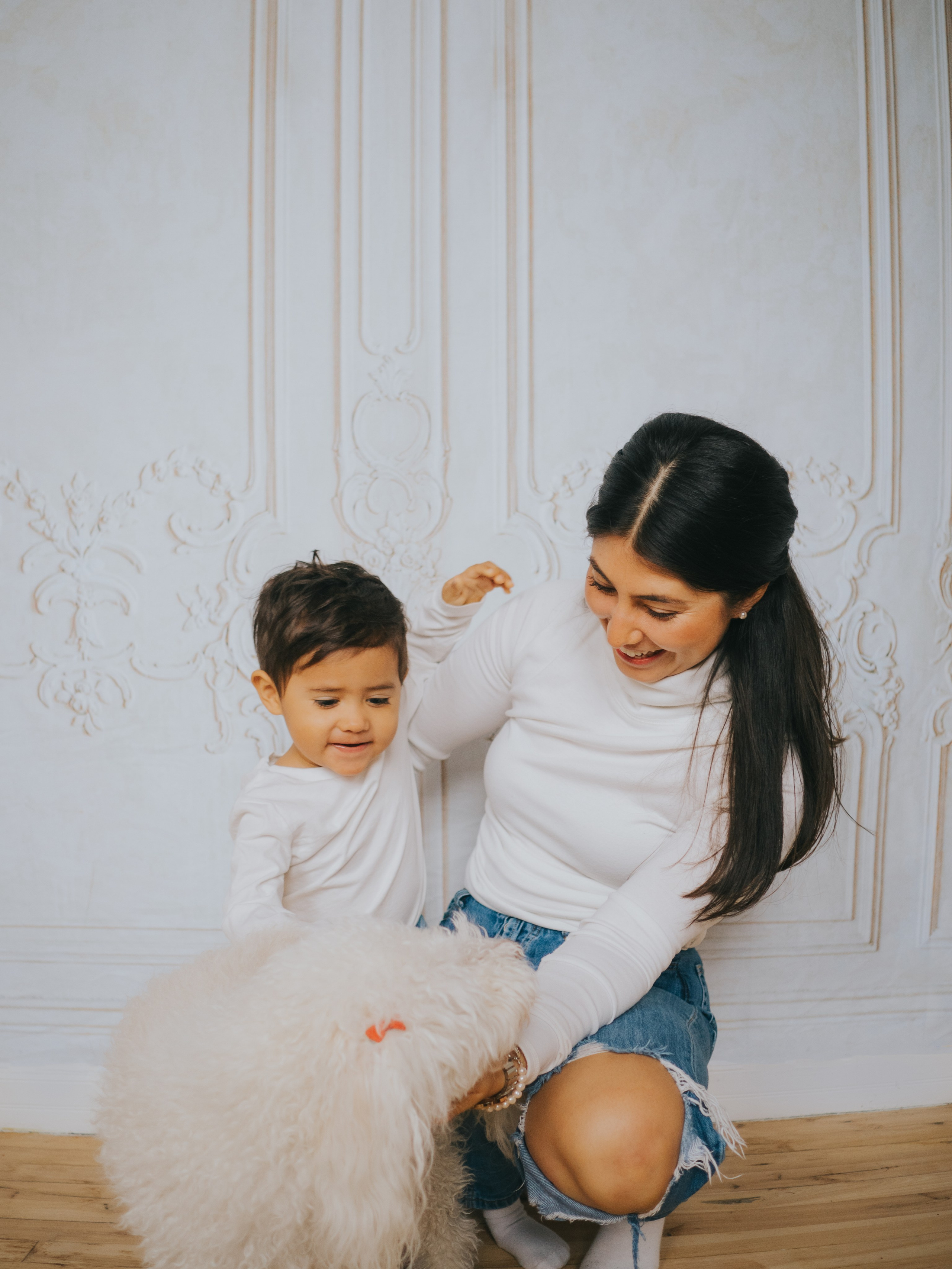 Mère et garçon jouant avec le chien dans le studio familial à Montréal.