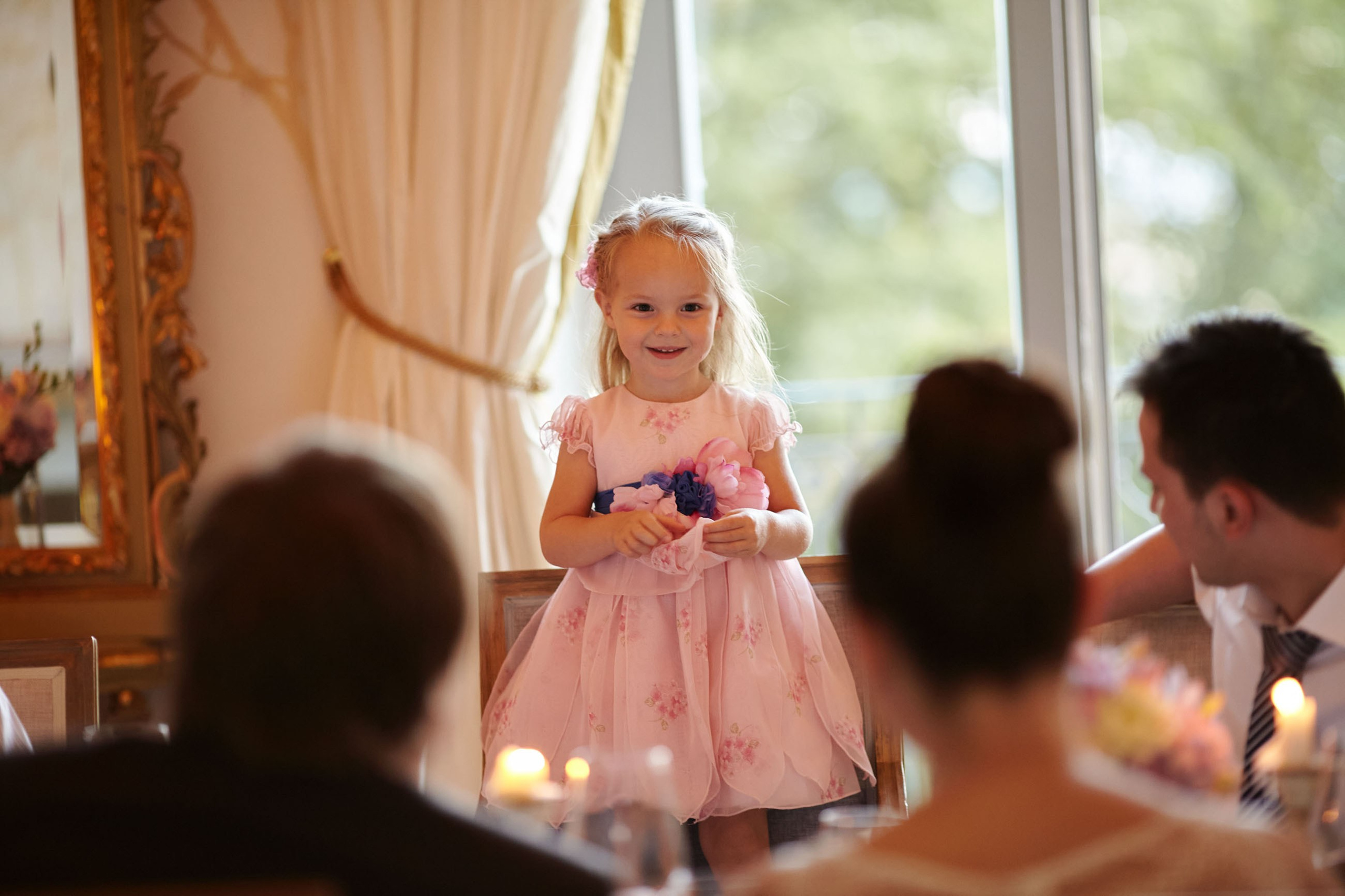 The young flower girl stands on her chair in order to perform a Russian song in honor of the newlyweds during their dinner at the Chateau Mcely.