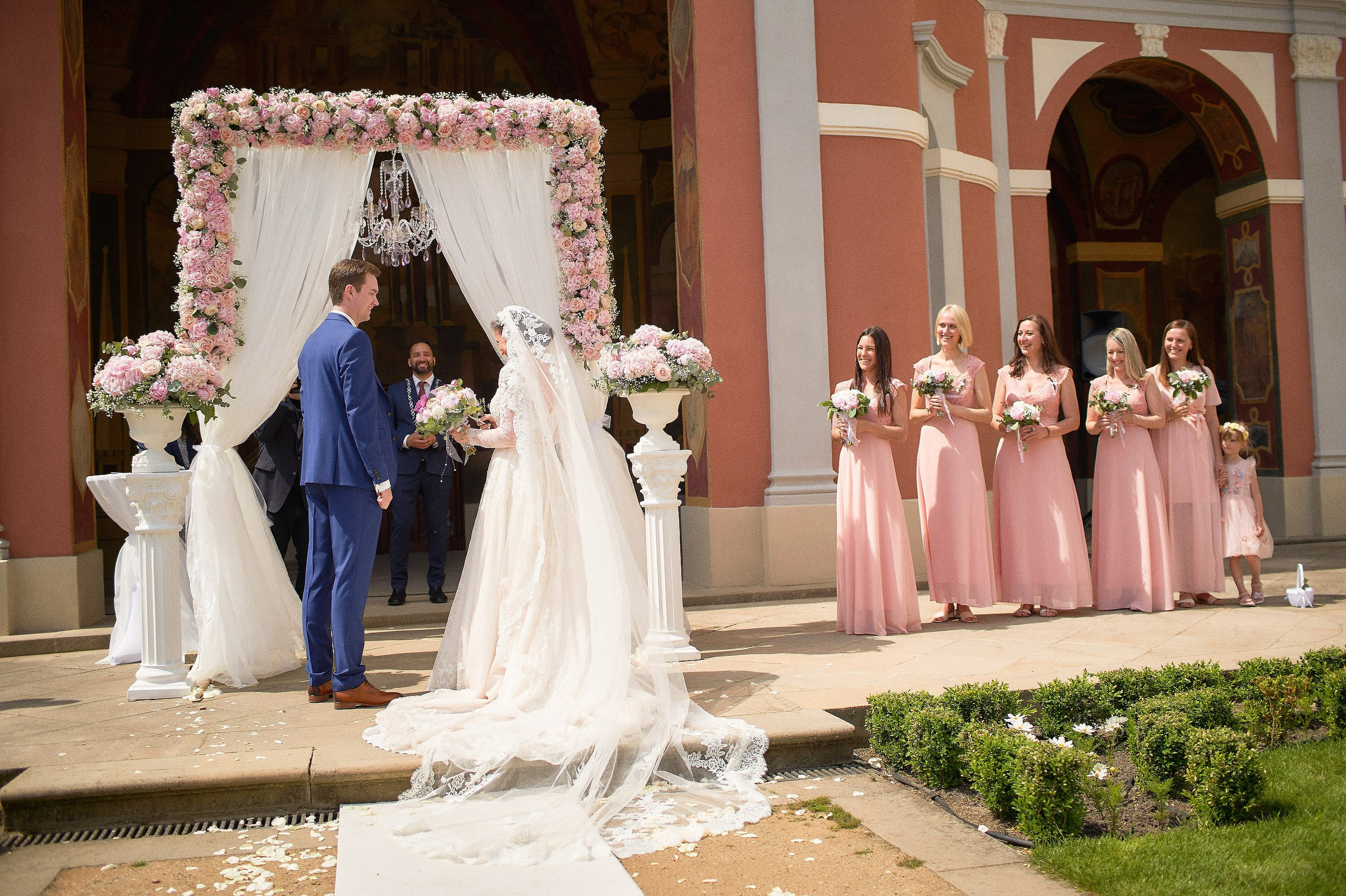 The bridesmaids stand at attention as the bride and groom exchange their vows at the historic Ledebour Garden.