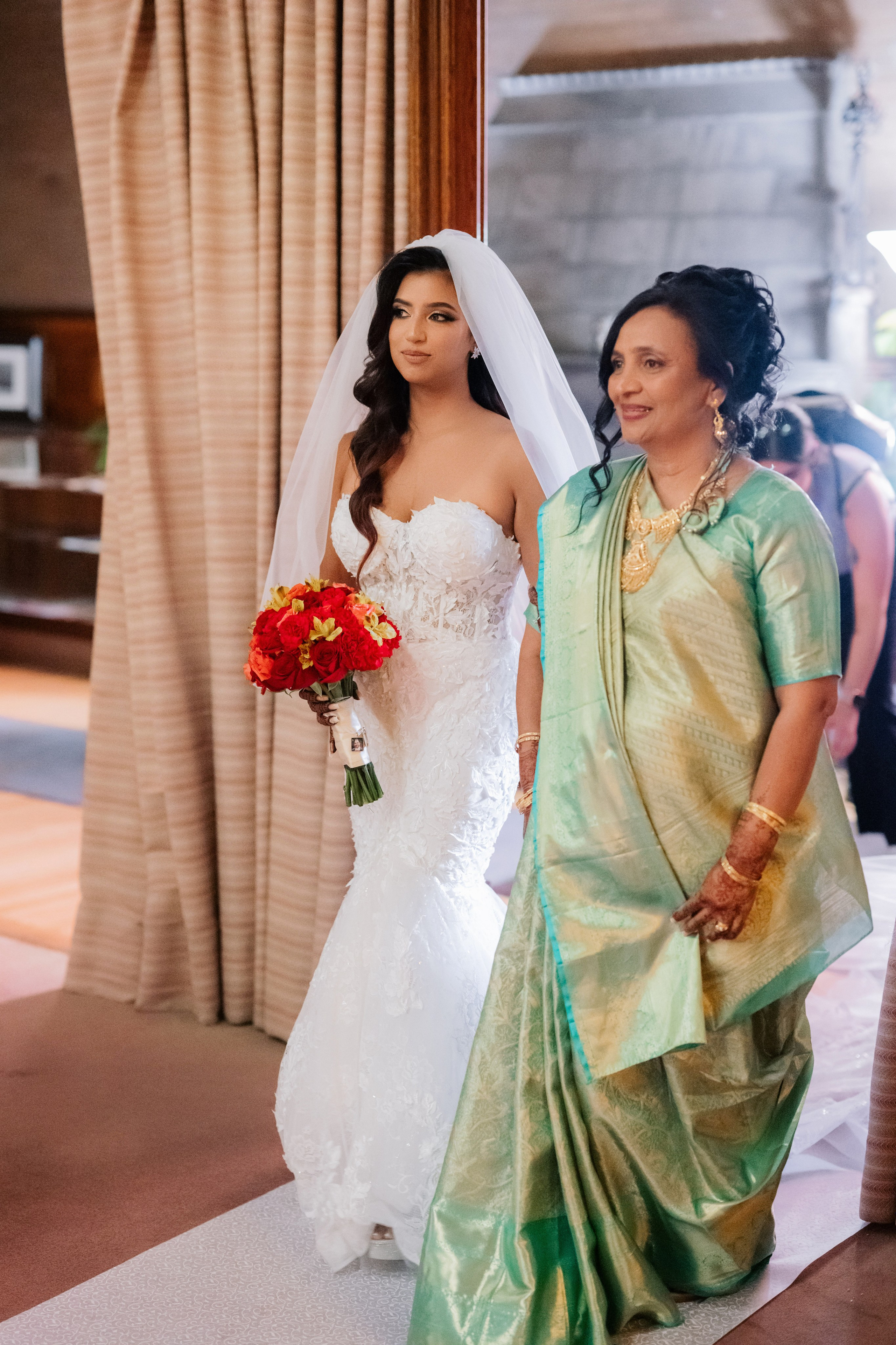 a bride and her mother walking down the aisle