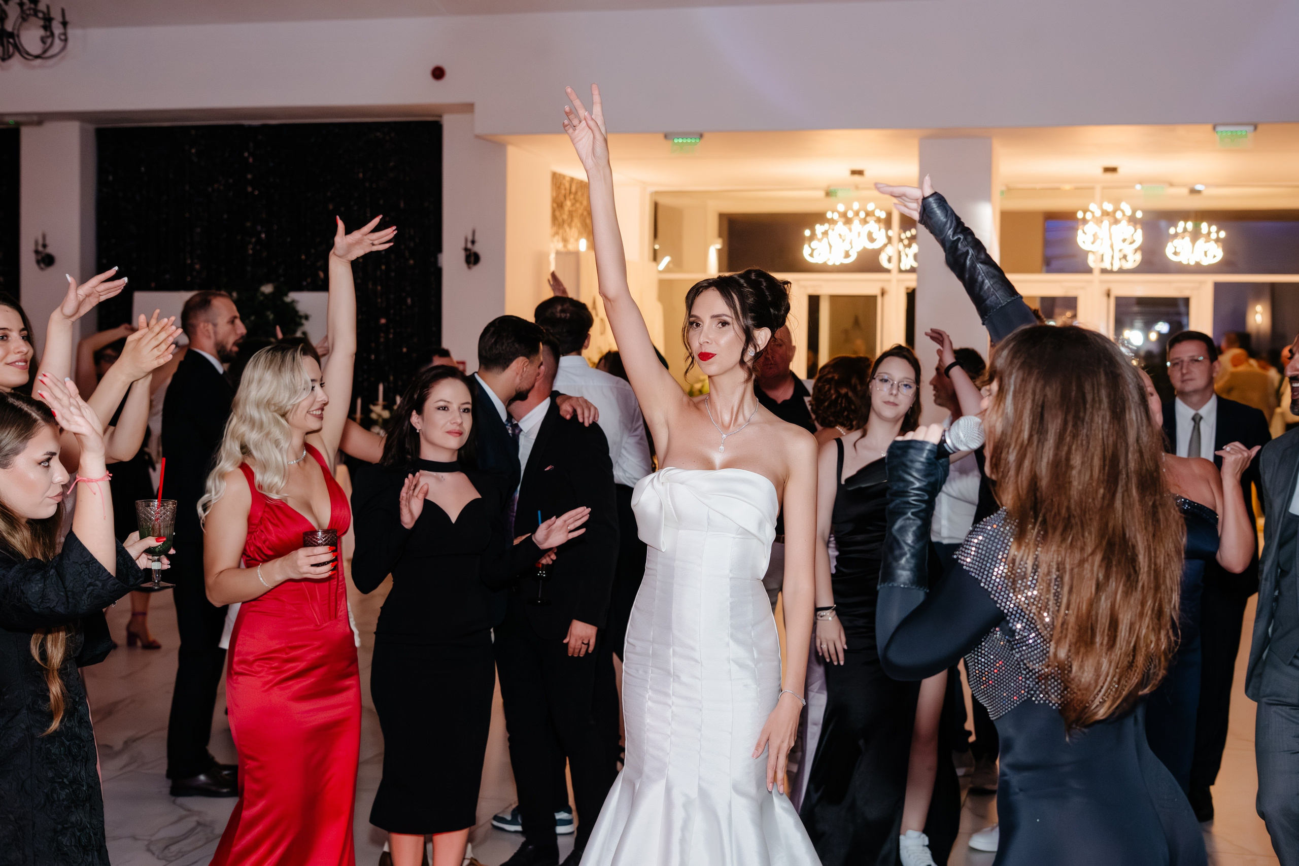 Cadru dinamic cu mirii și prietenii dansând la petrecerea din Bacău.