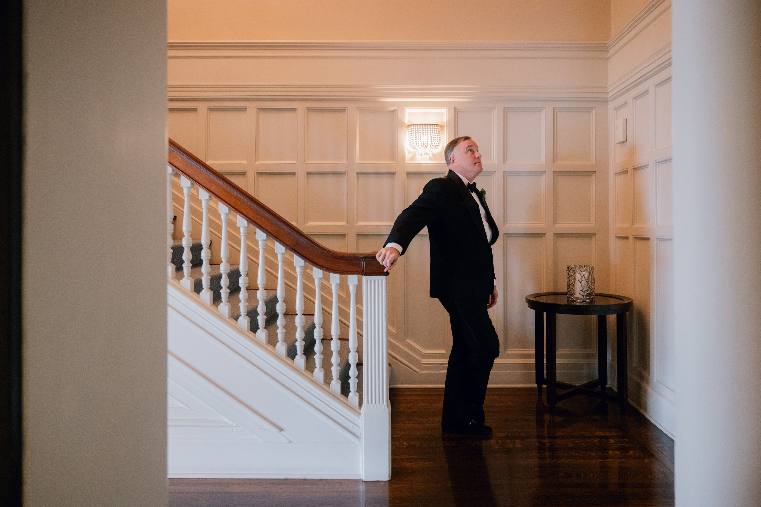 a man in a suit standing at the top of a staircase