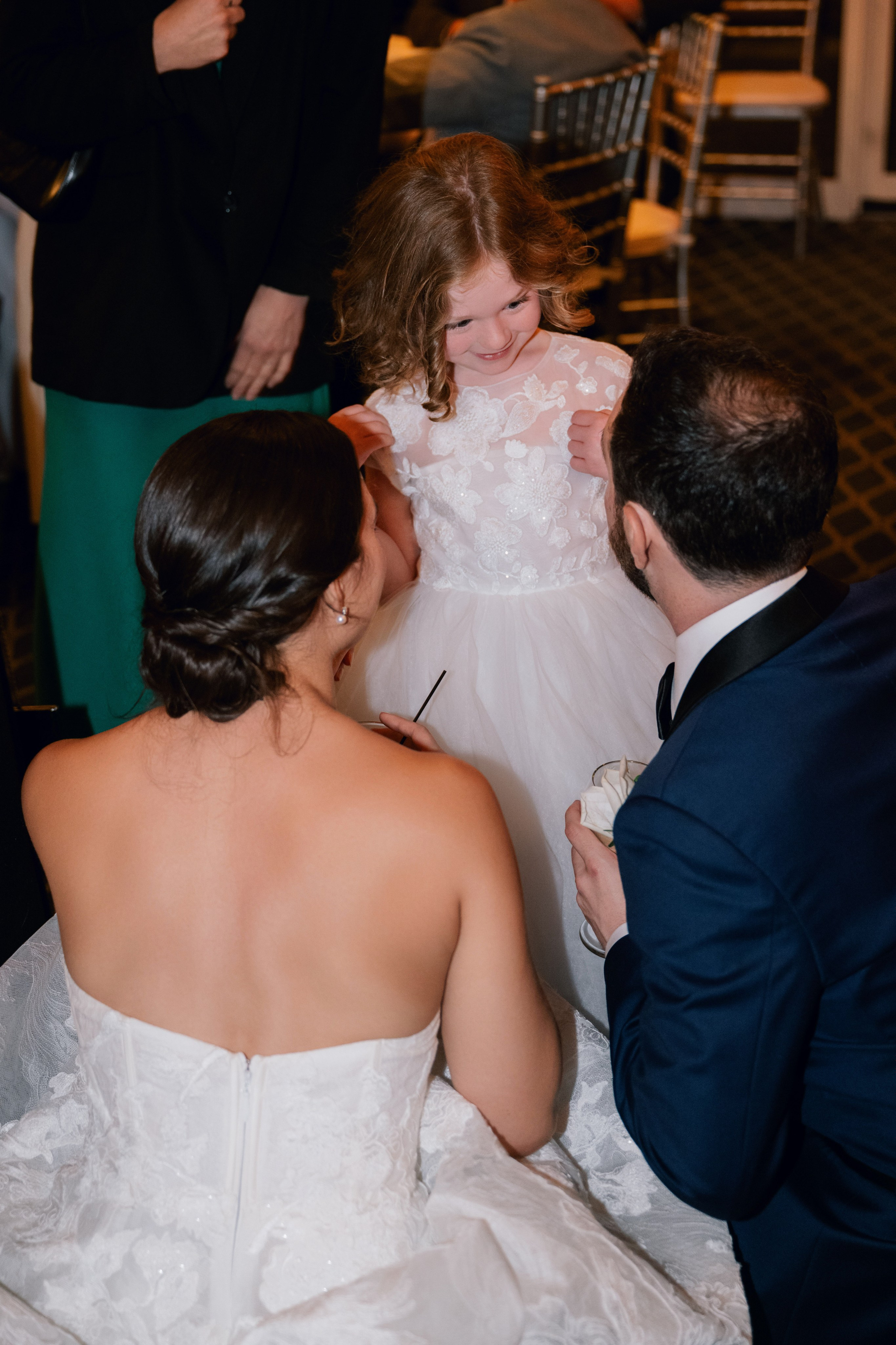 a bride and her flower girl are sitting on the floor