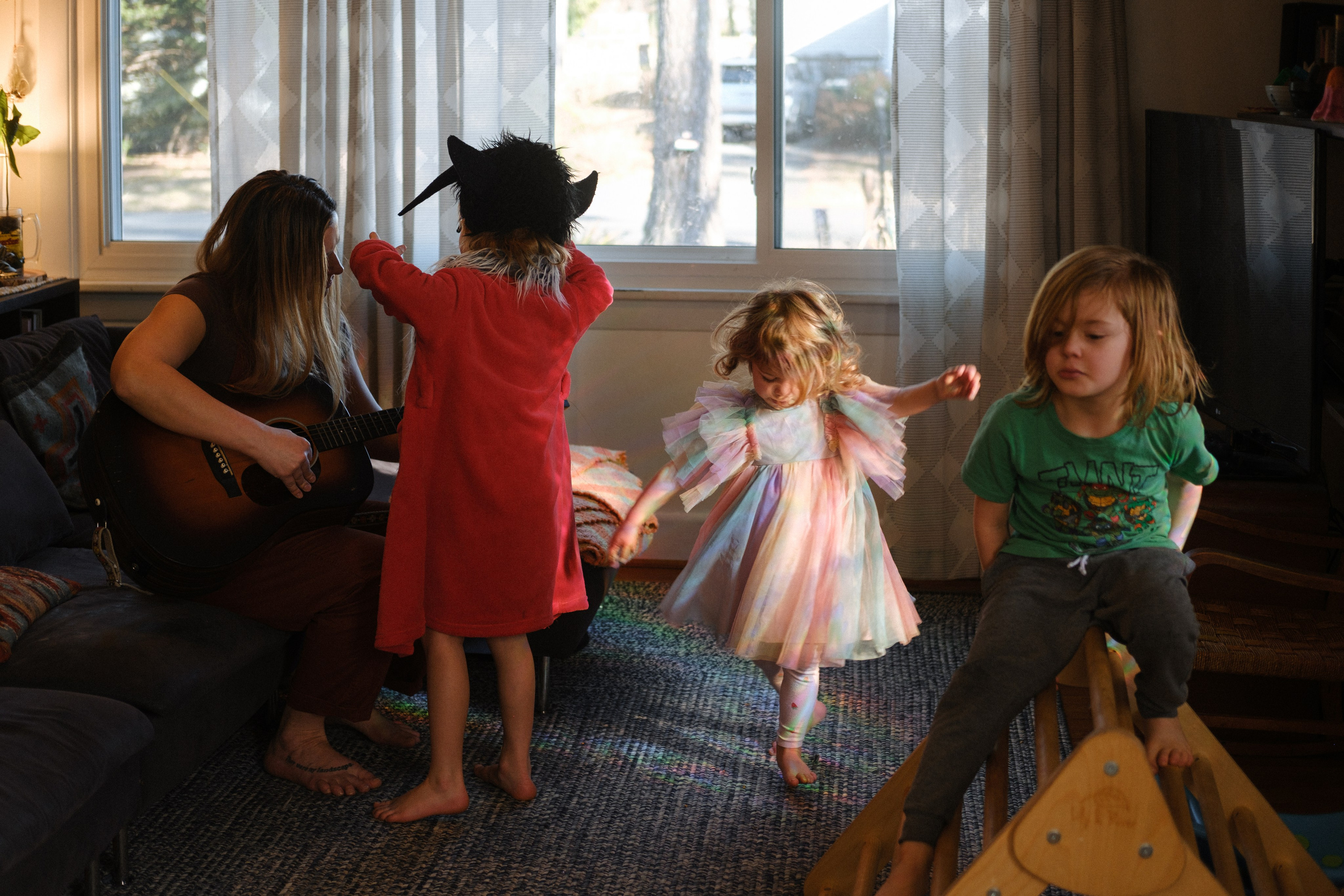 Documentary-style family photography in Richmond VA; a family cuddled on a sofa, leaning into each other with natural, comfortable body language.