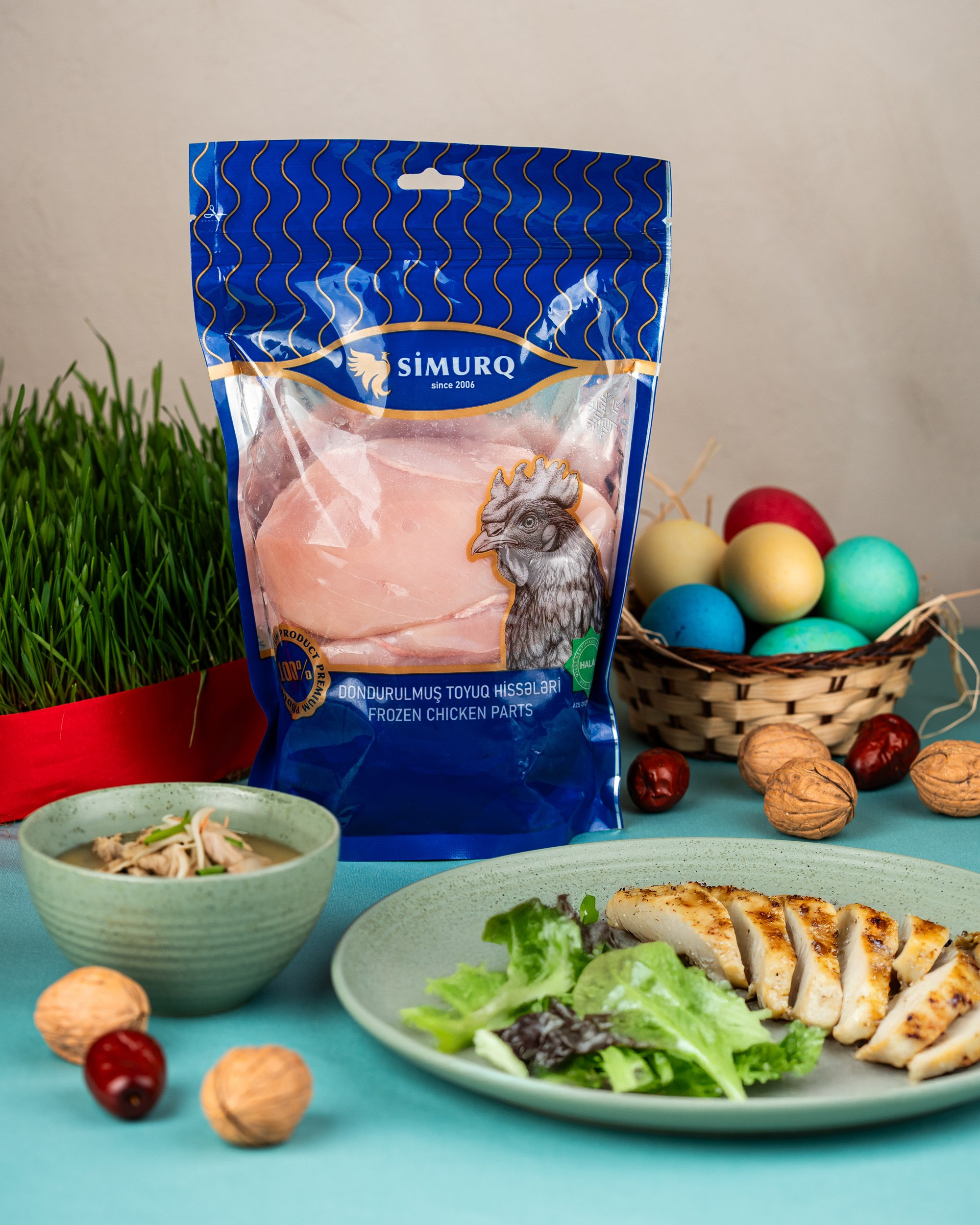 Simurq dondurulmuş toyuq filesi məhsulu – qablaşdırmada və bişmiş formada salatla birlikdə Novruz dekorasiyalı qida fotoqrafiyası