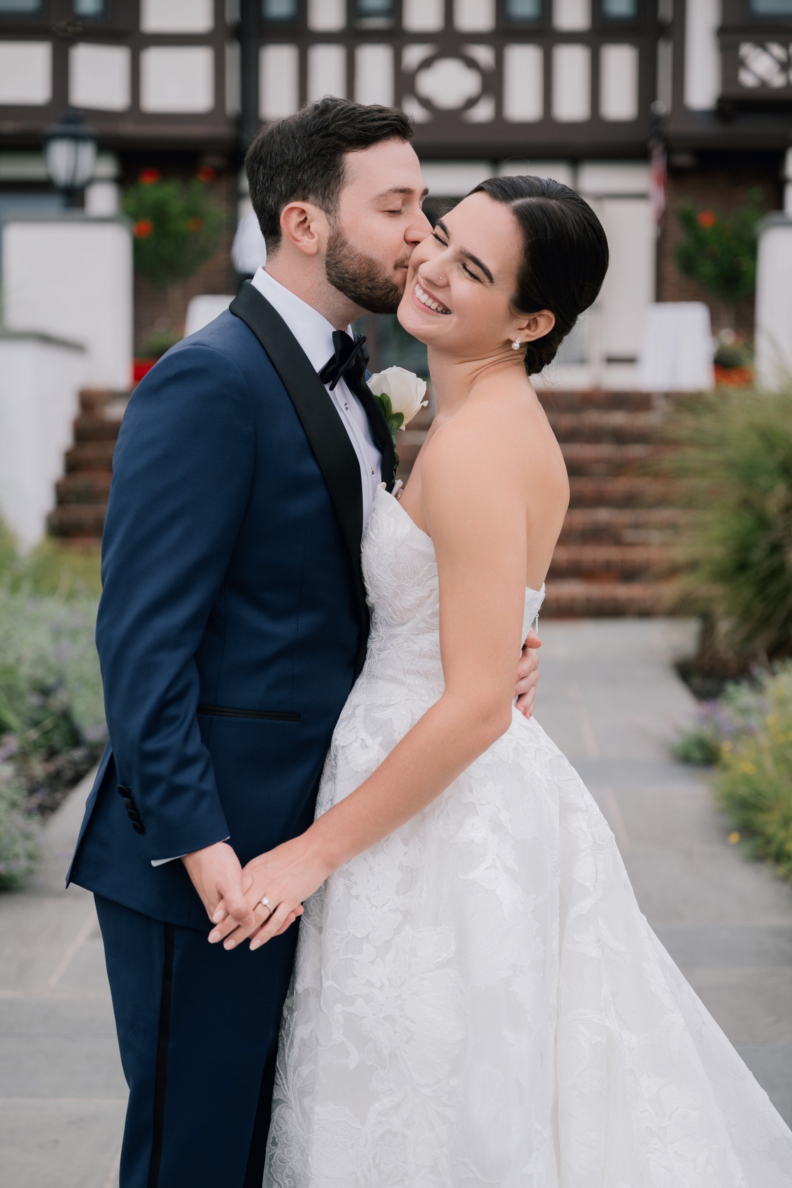 a bride and groom kissing in front of a building