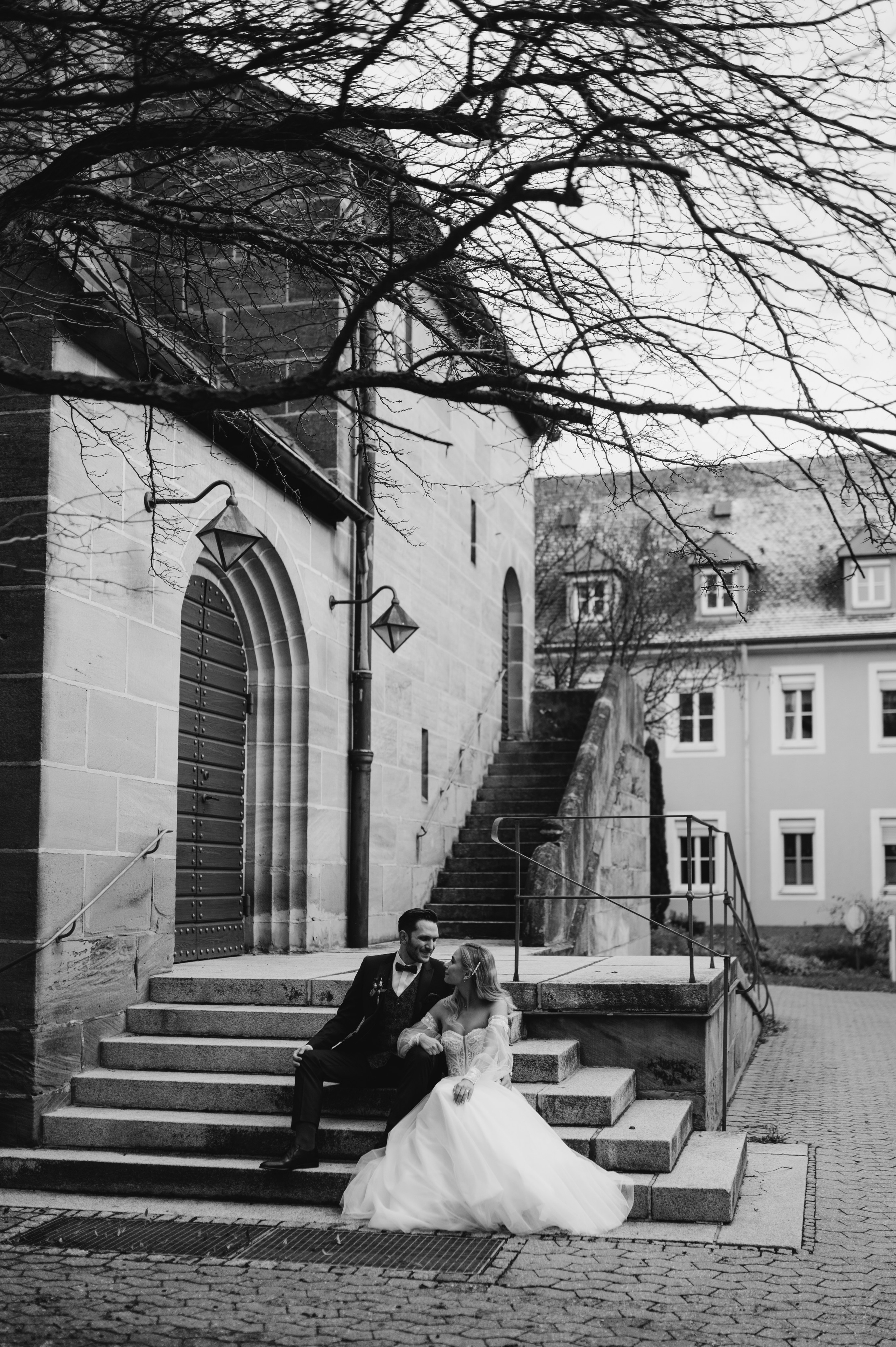 Braurpaar kuschelt sich an den Stufen von der Kirche in Neuendettelsau