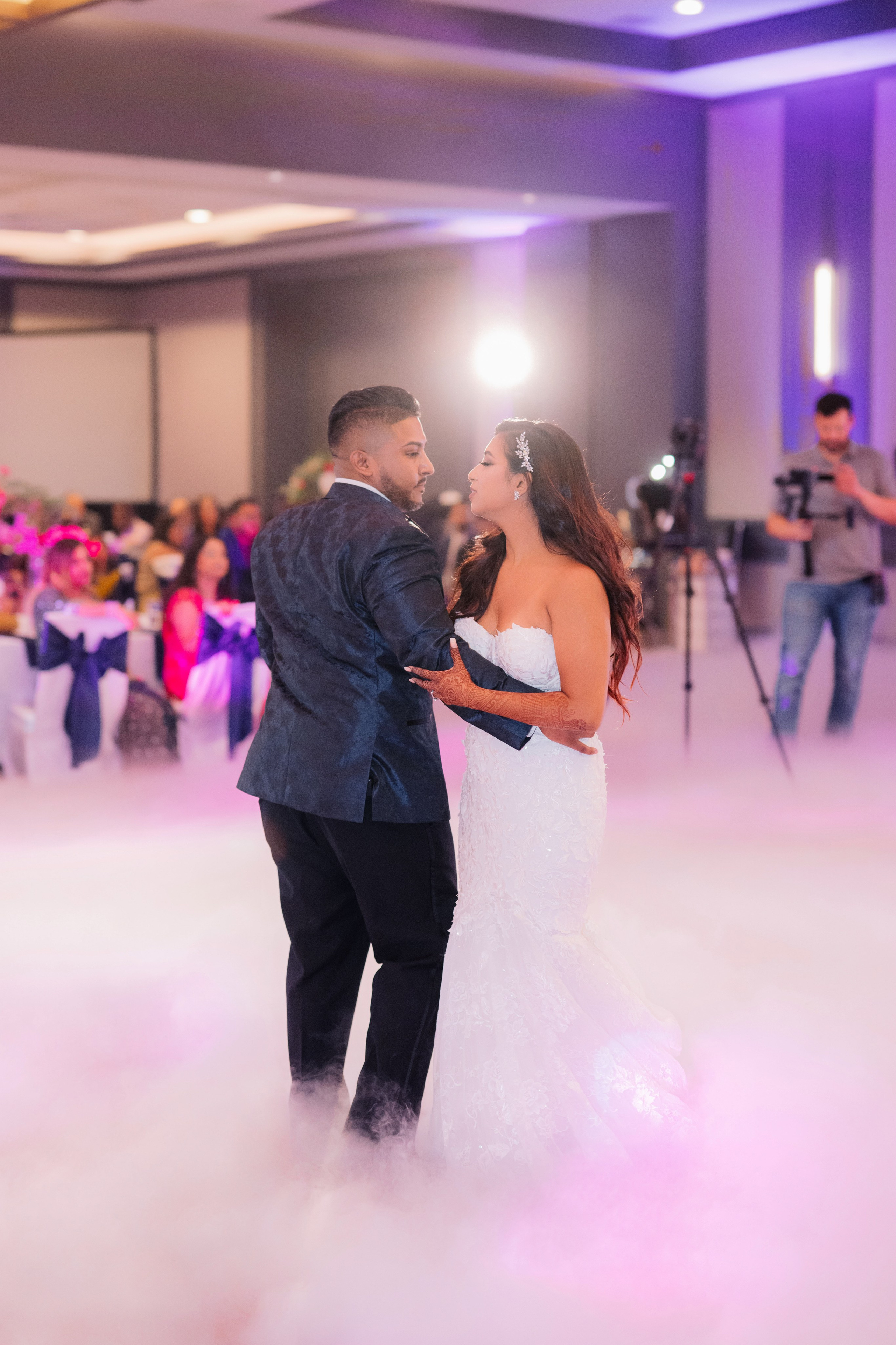 a bride and groom dance in the clouds