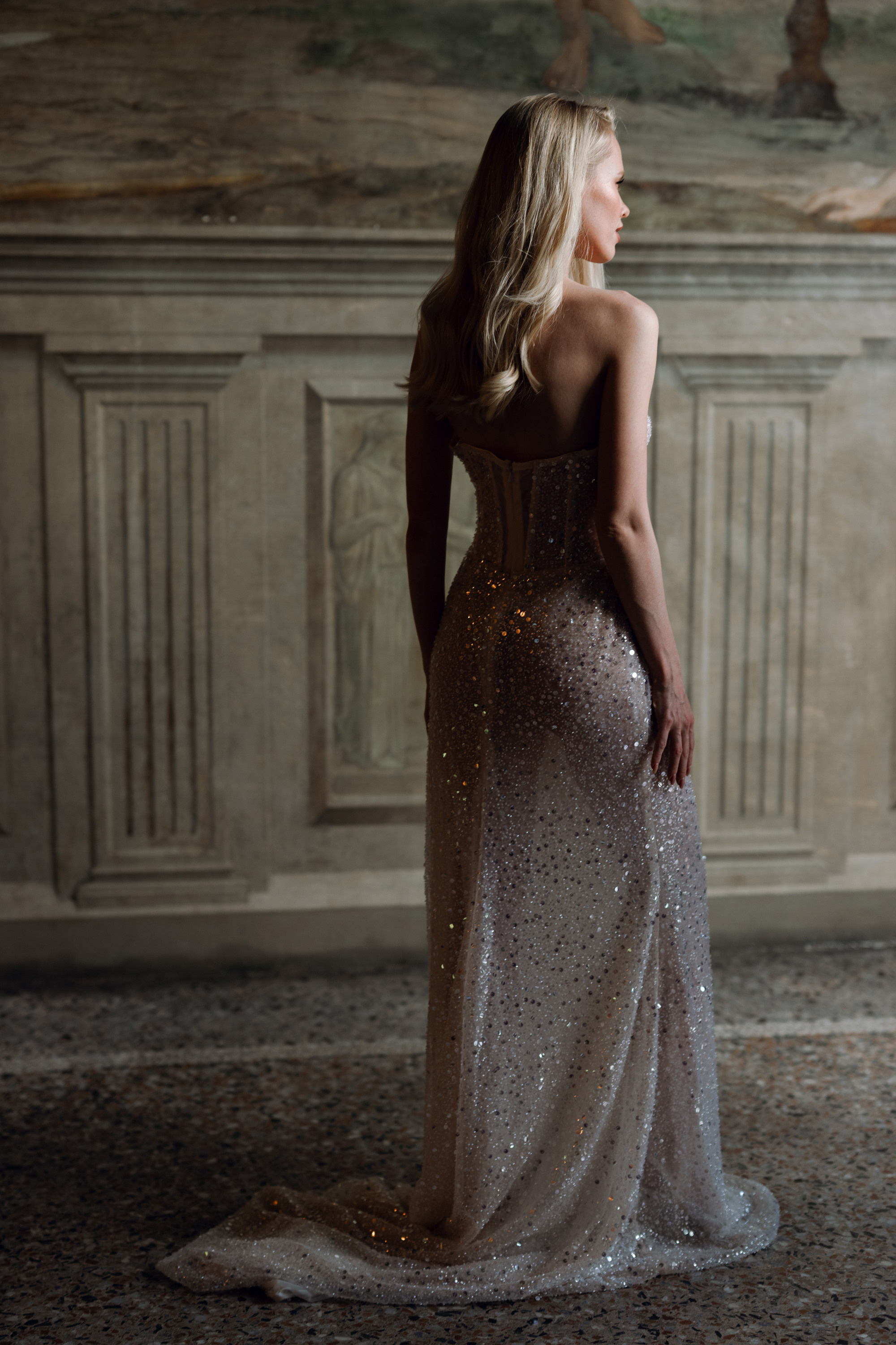 a woman in a dress standing in front of a wall