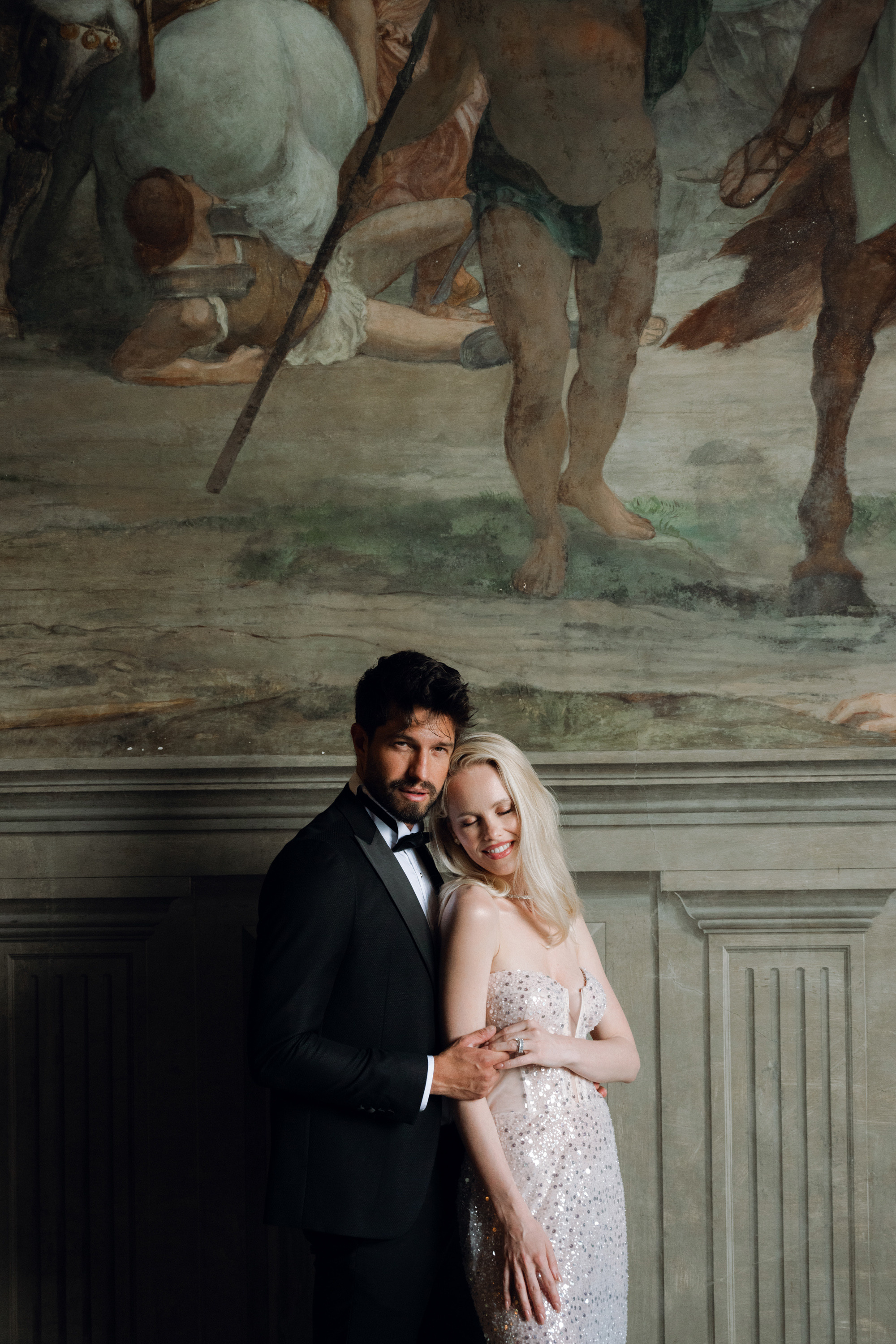 a man and woman standing in front of a painting