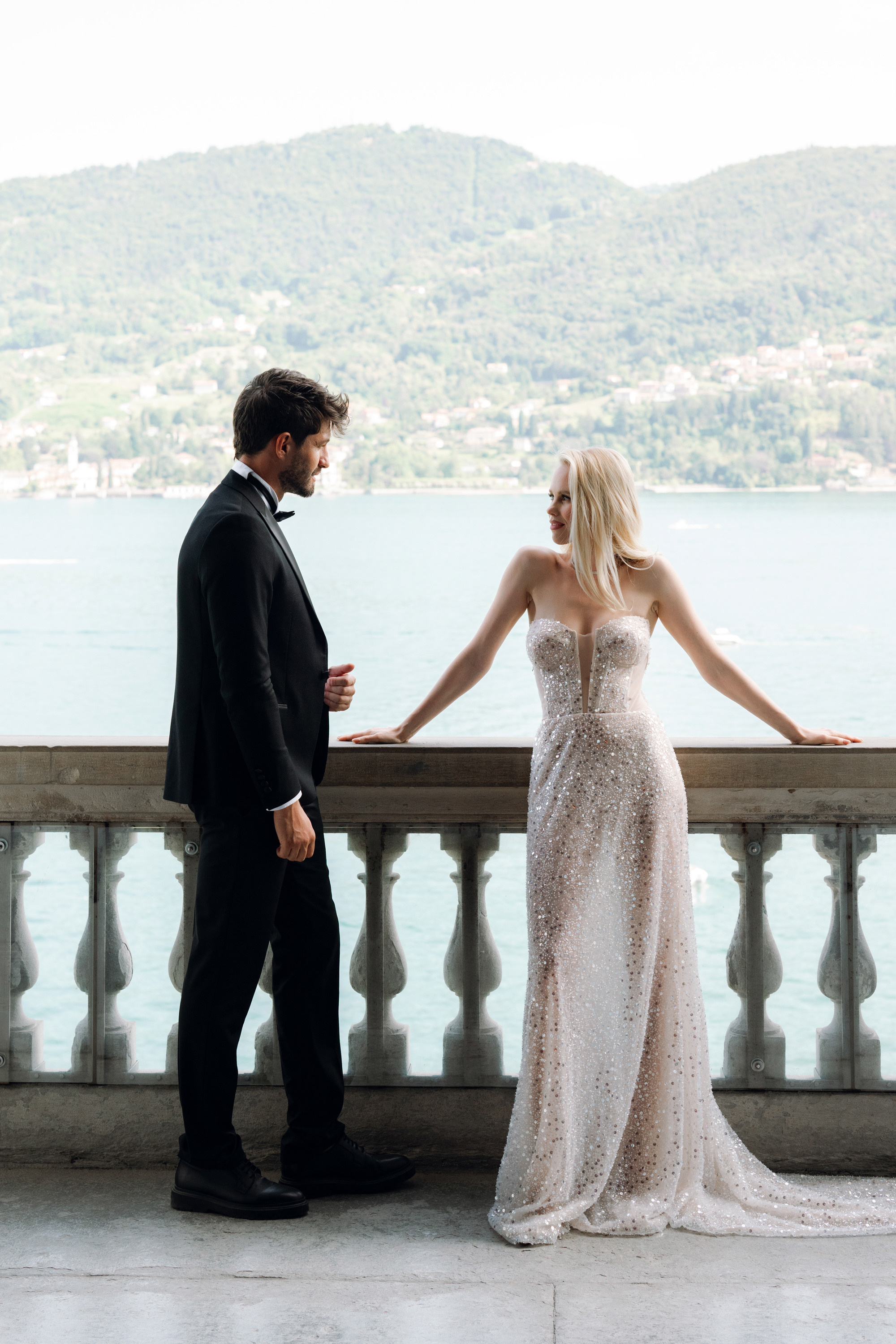 a bride and groom standing on a bridge