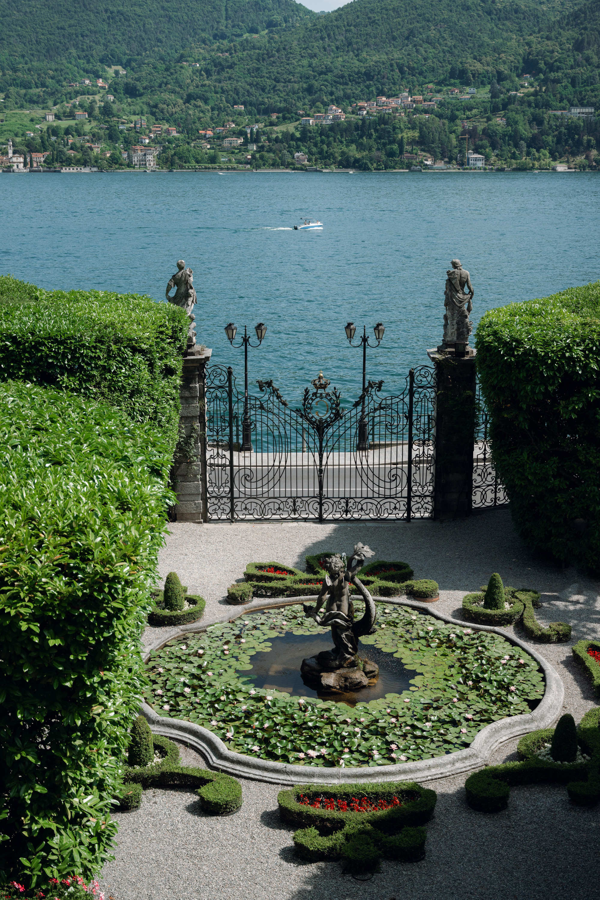 a fountain with a statue in the middle of a garden