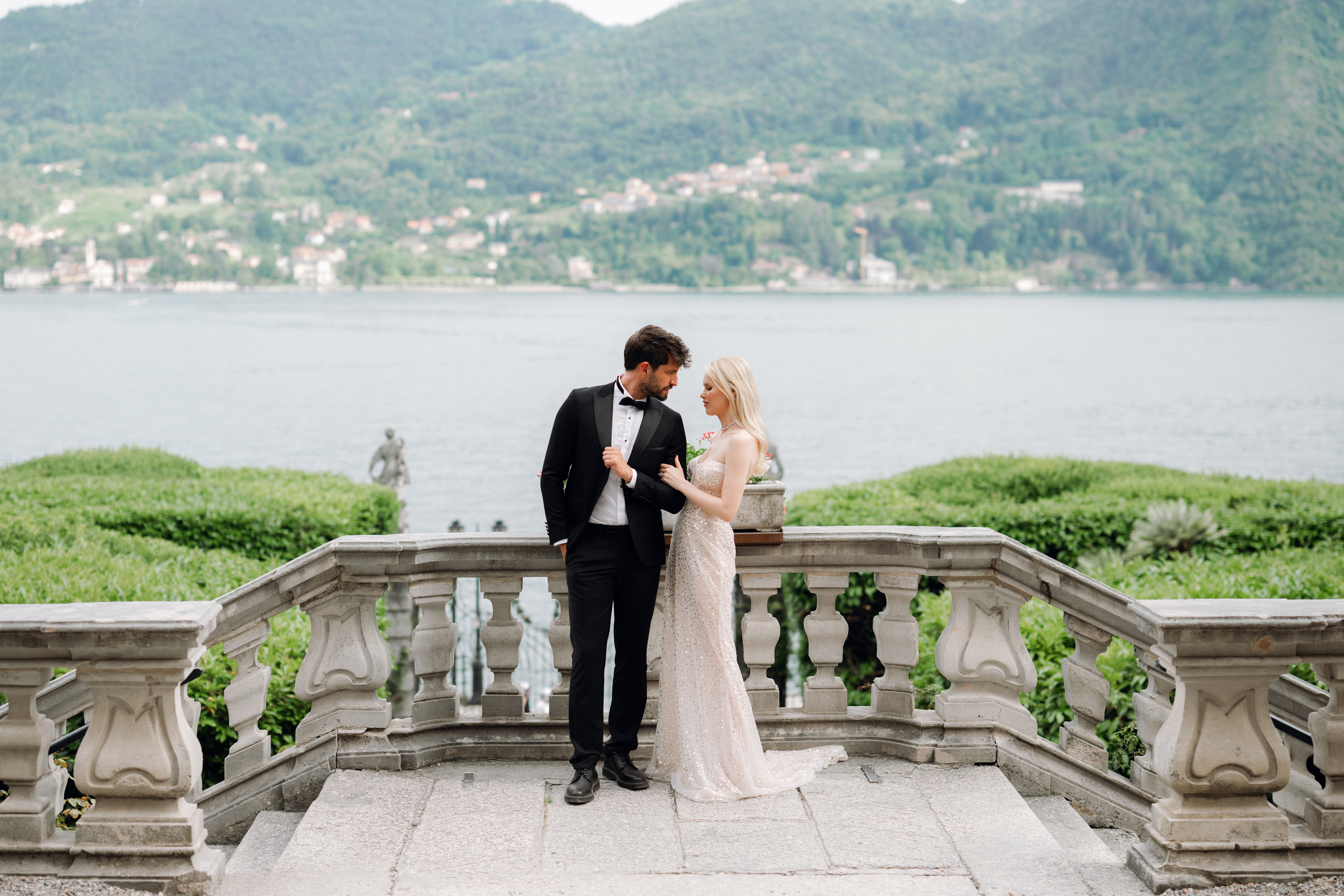 a bride and groom standing on a stone bridge
