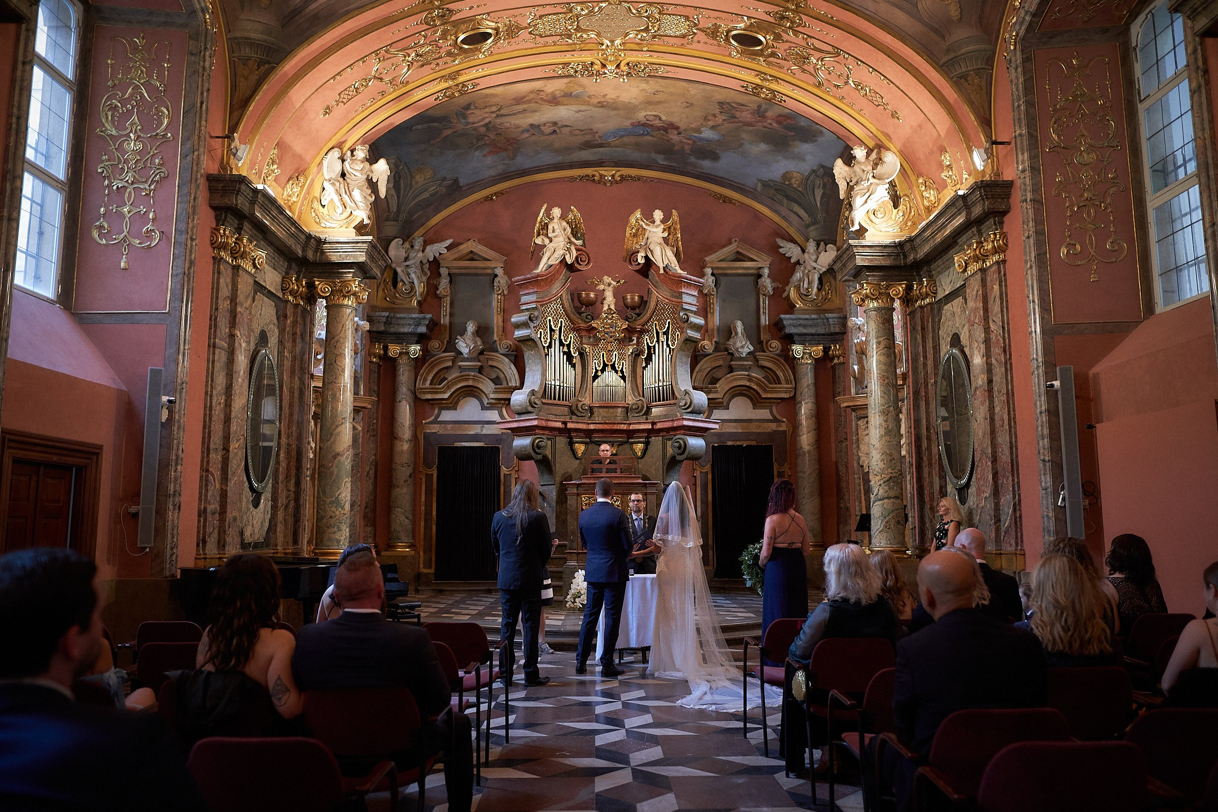 Bride and groom reciting personal vows at Klementinum altar.