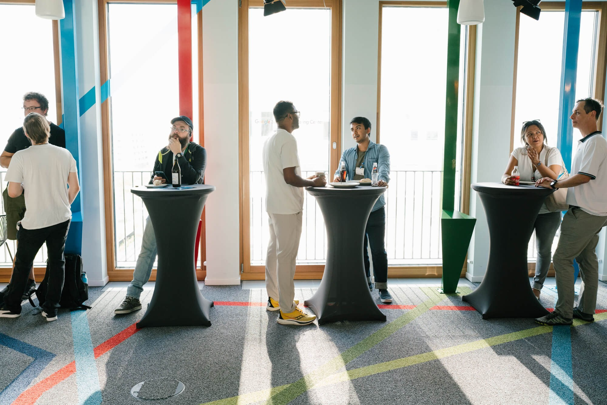 Teilnehmende beim Networking in einem hellen Eventraum eines Google Developer Groups Meetups